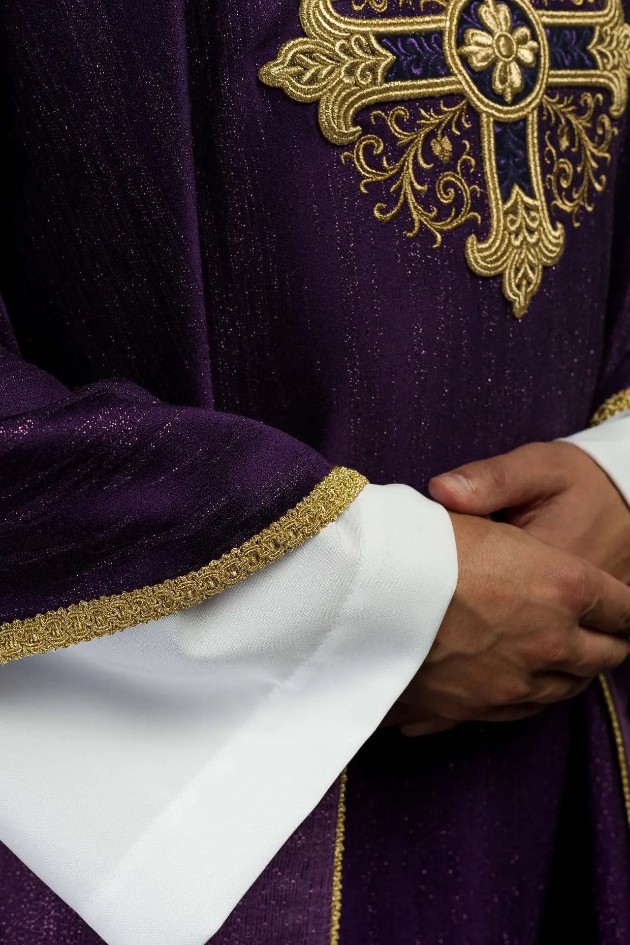 Purple liturgical chasuble with an embroidered cross motif on decorative fabric