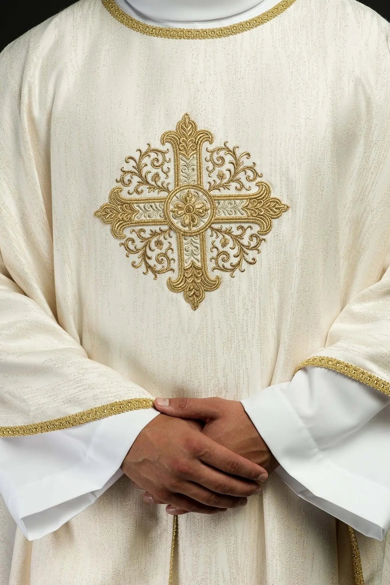 Ecru chasuble with embroidered cross motif on decorative fabric