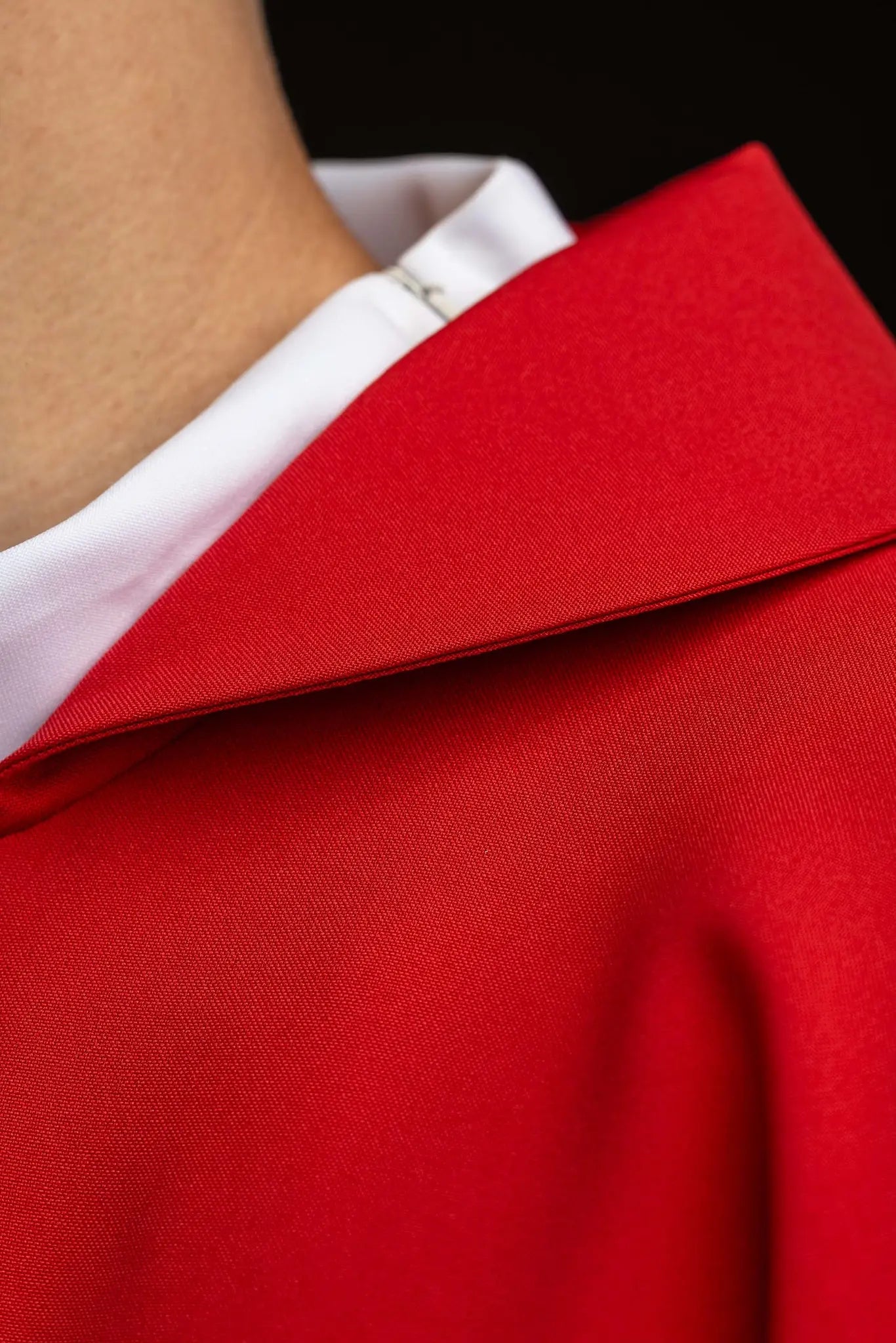 Red chasuble with gold IHS embroidery on the front and back, finished with gold trim and a V-neckline.