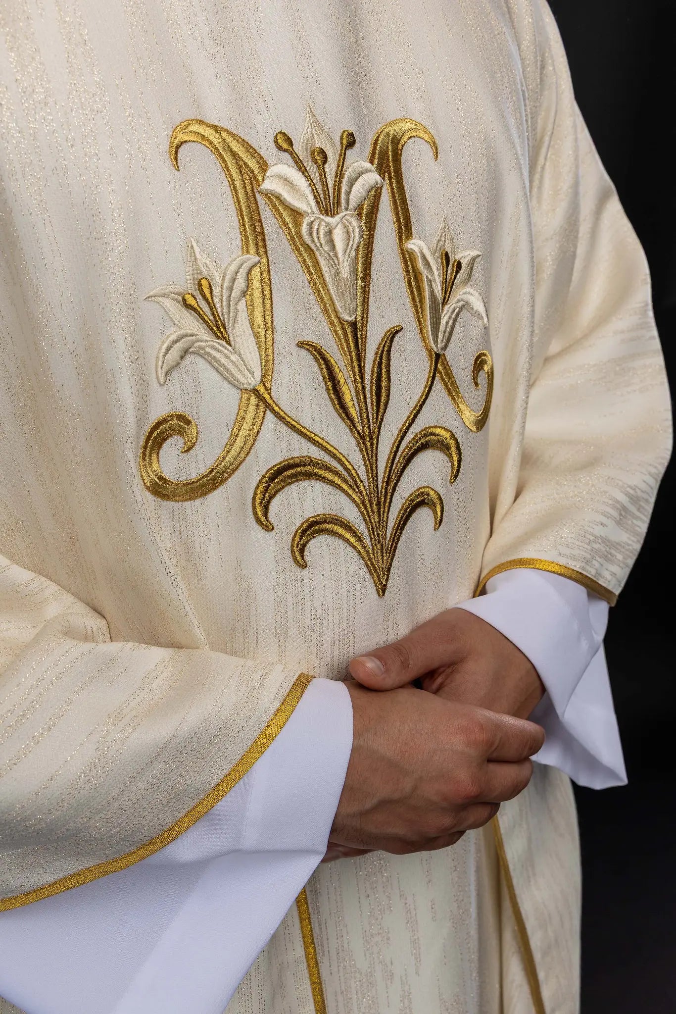 Ecru chasuble with Marian lily embroidery, gold collar, and gold trim.