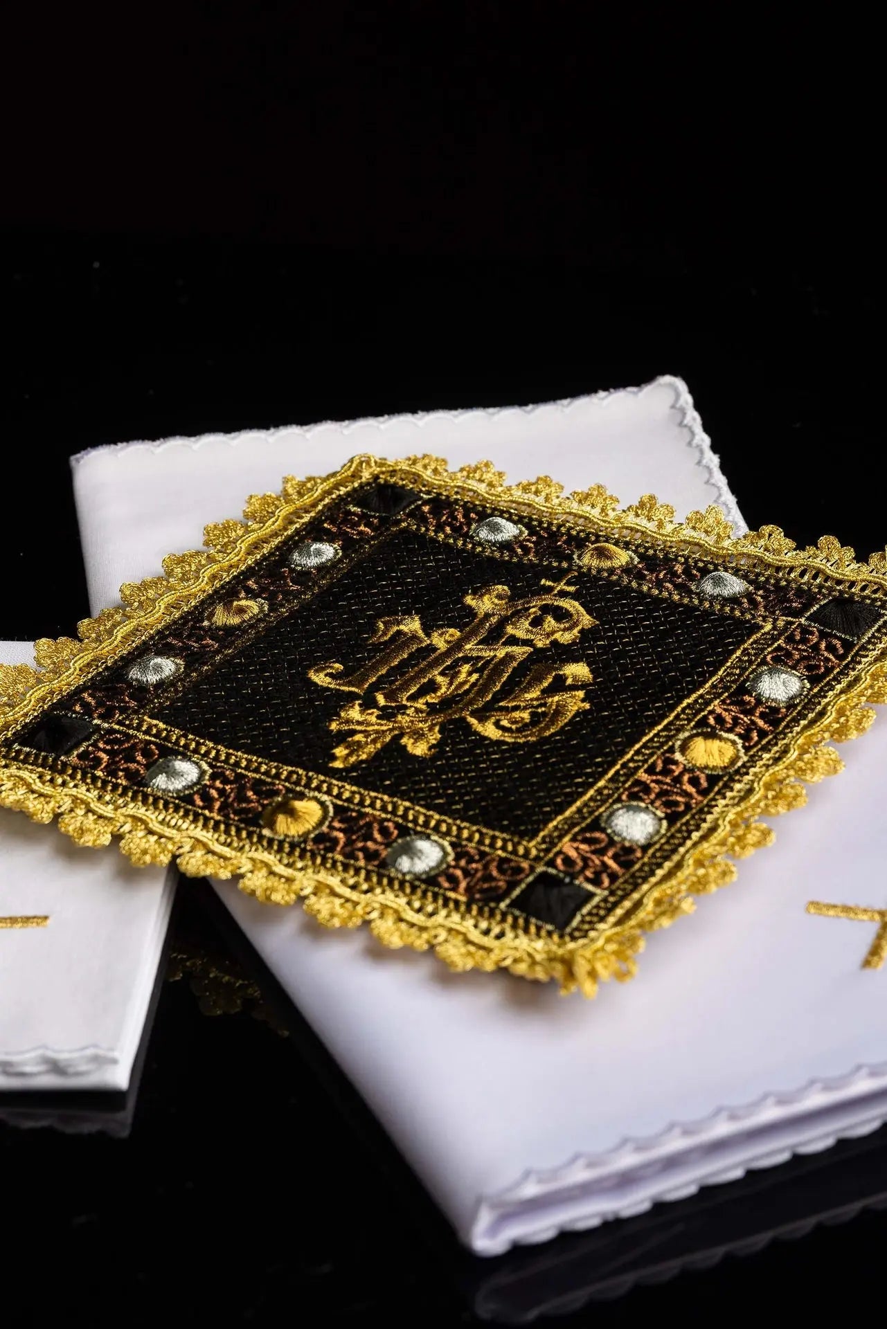 A black velvet chalice linens set with an embroidered IHS symbol