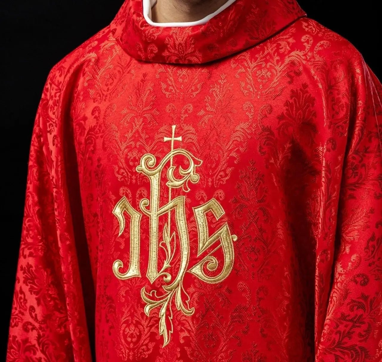 Red chasuble with embroidered IHS motif on decorative fabric
