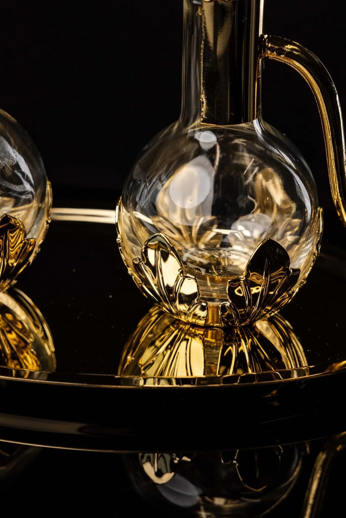Gold liturgical cruet with floral accents and handle, close-up view