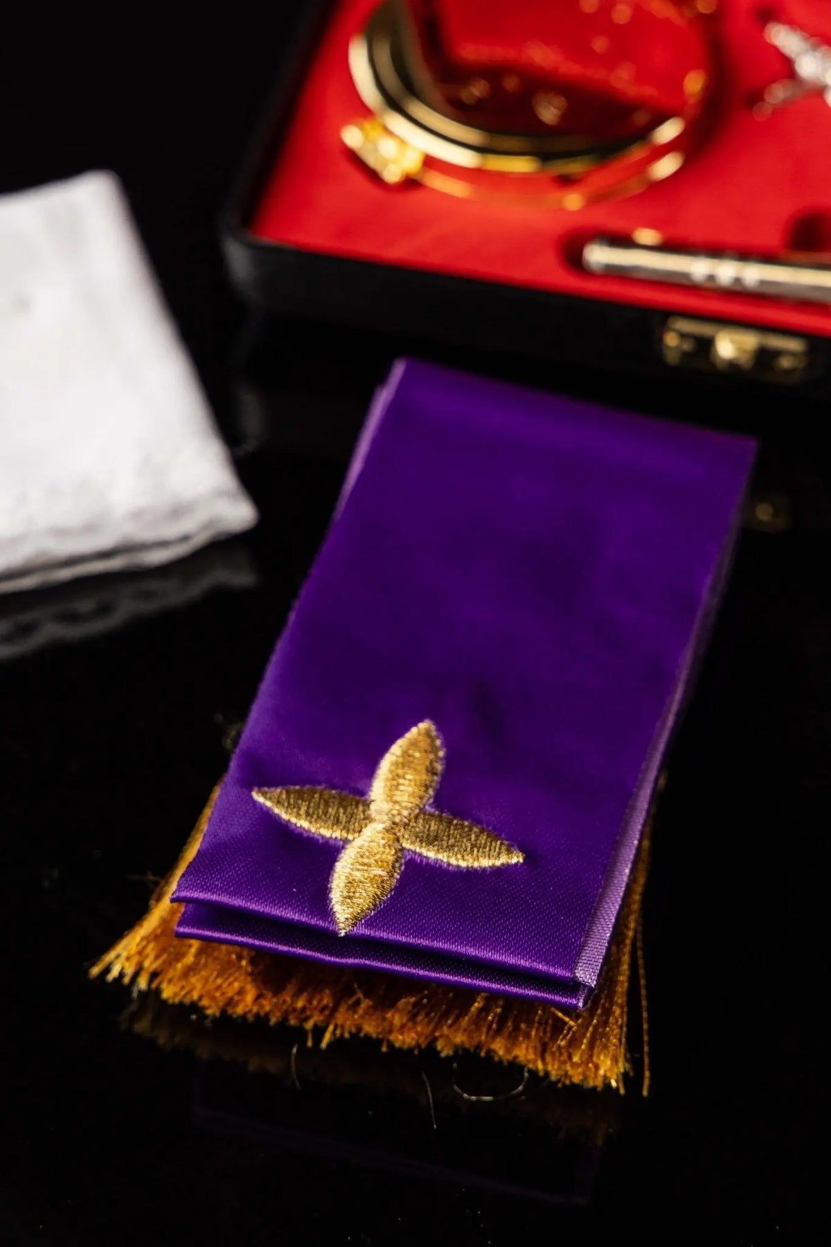 Purple liturgical stole with gold cross, close-up view with gold fringe