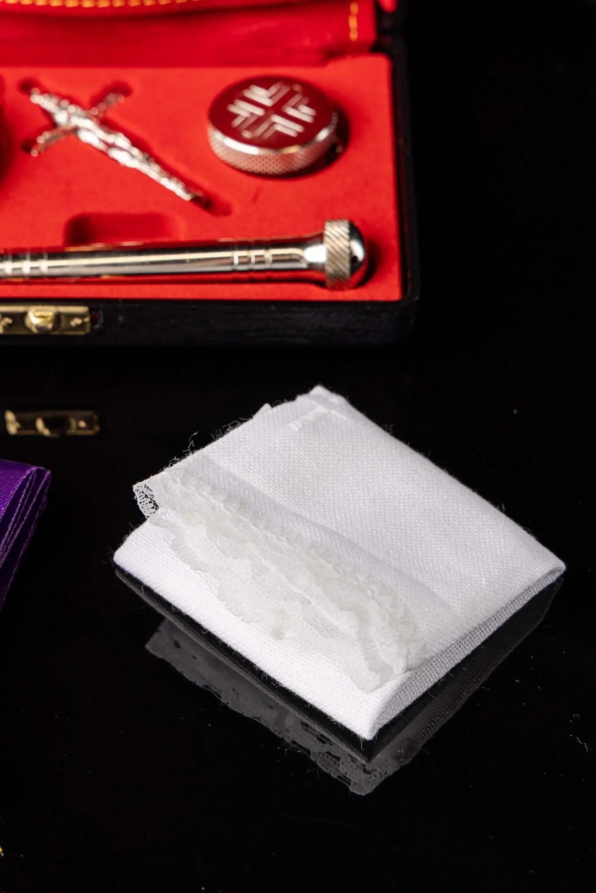 White liturgical purificator, folded close-up view with lace trim