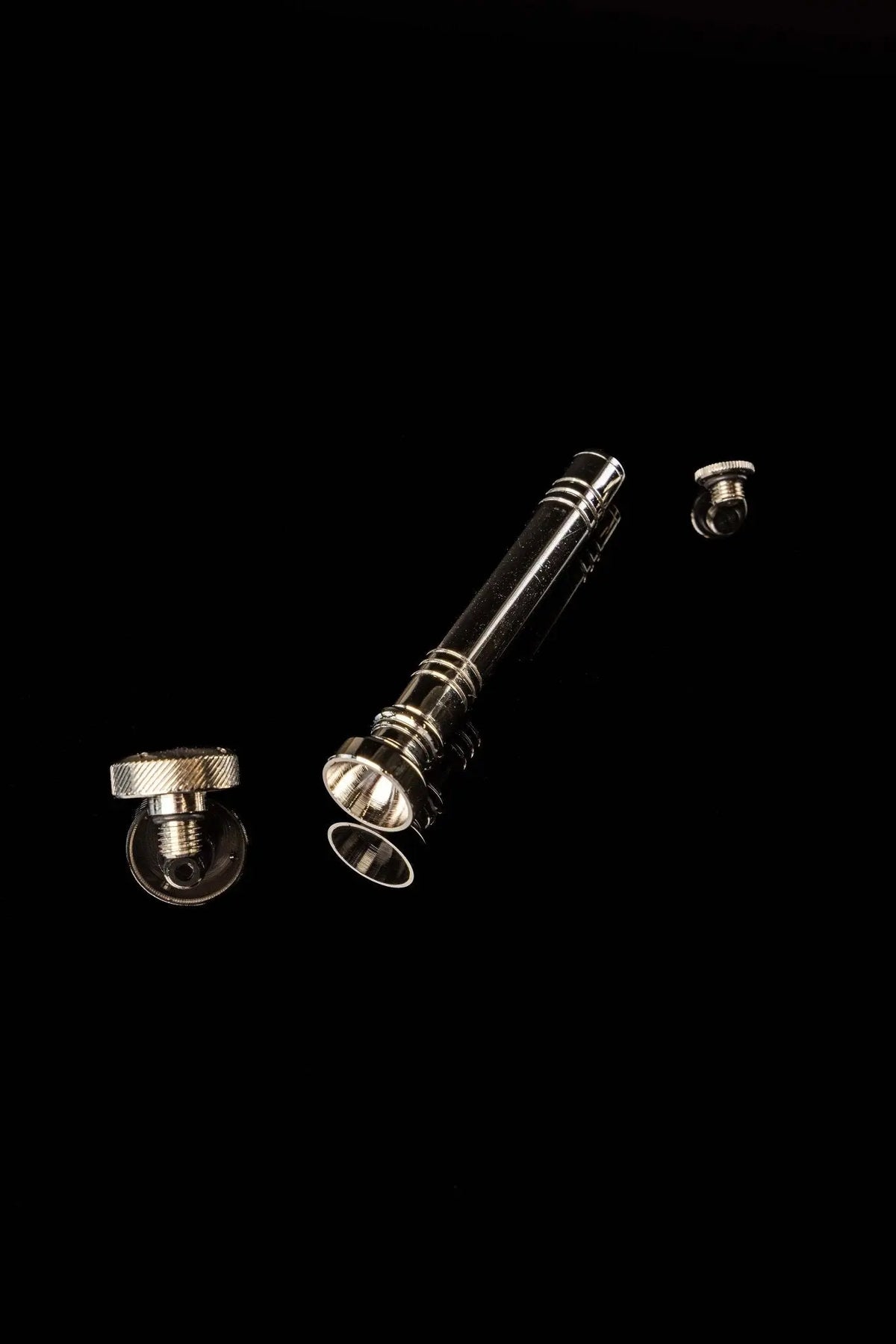 Silver aspergillum with detachable ridged end caps, disassembled view