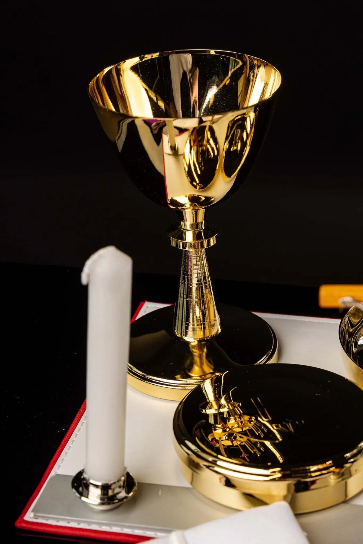 Rosso equipaggiamento liturgico con calice dorato e candele, dettaglio ravvicinato