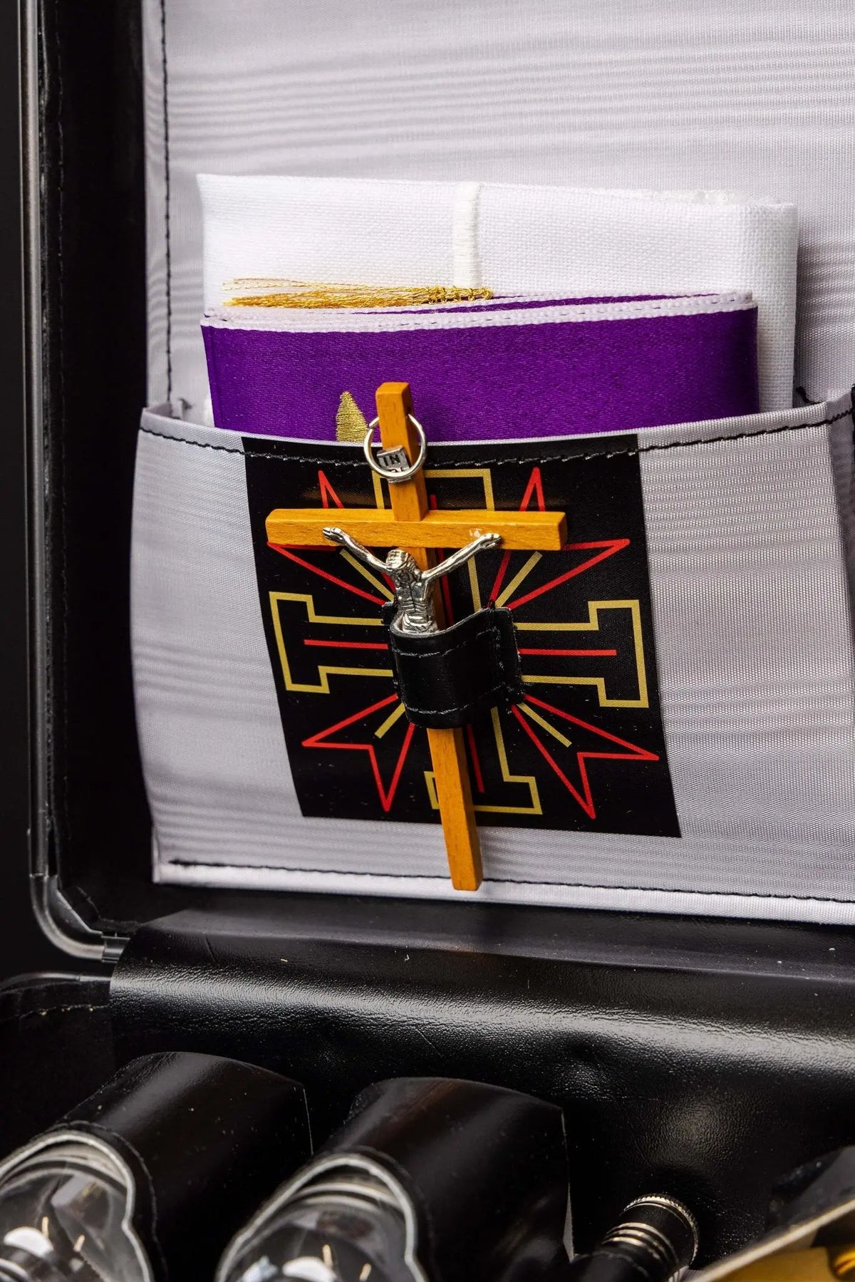 Nera valigia liturgica con croce e motivo geometrico rosso e oro, dettaglio interno