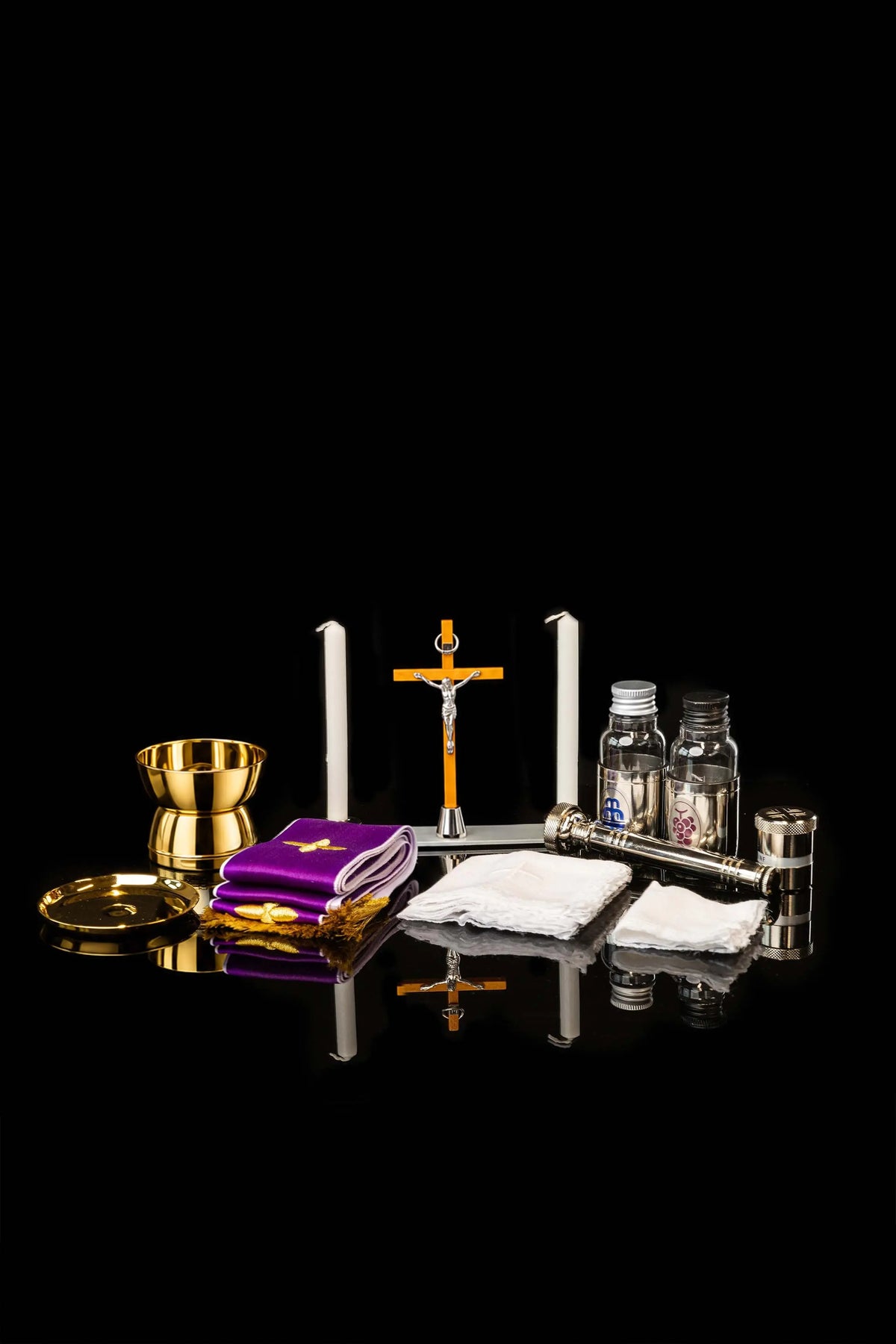 Valigetta liturgica bordeaux aperta con calice, candele e croce, vista frontale