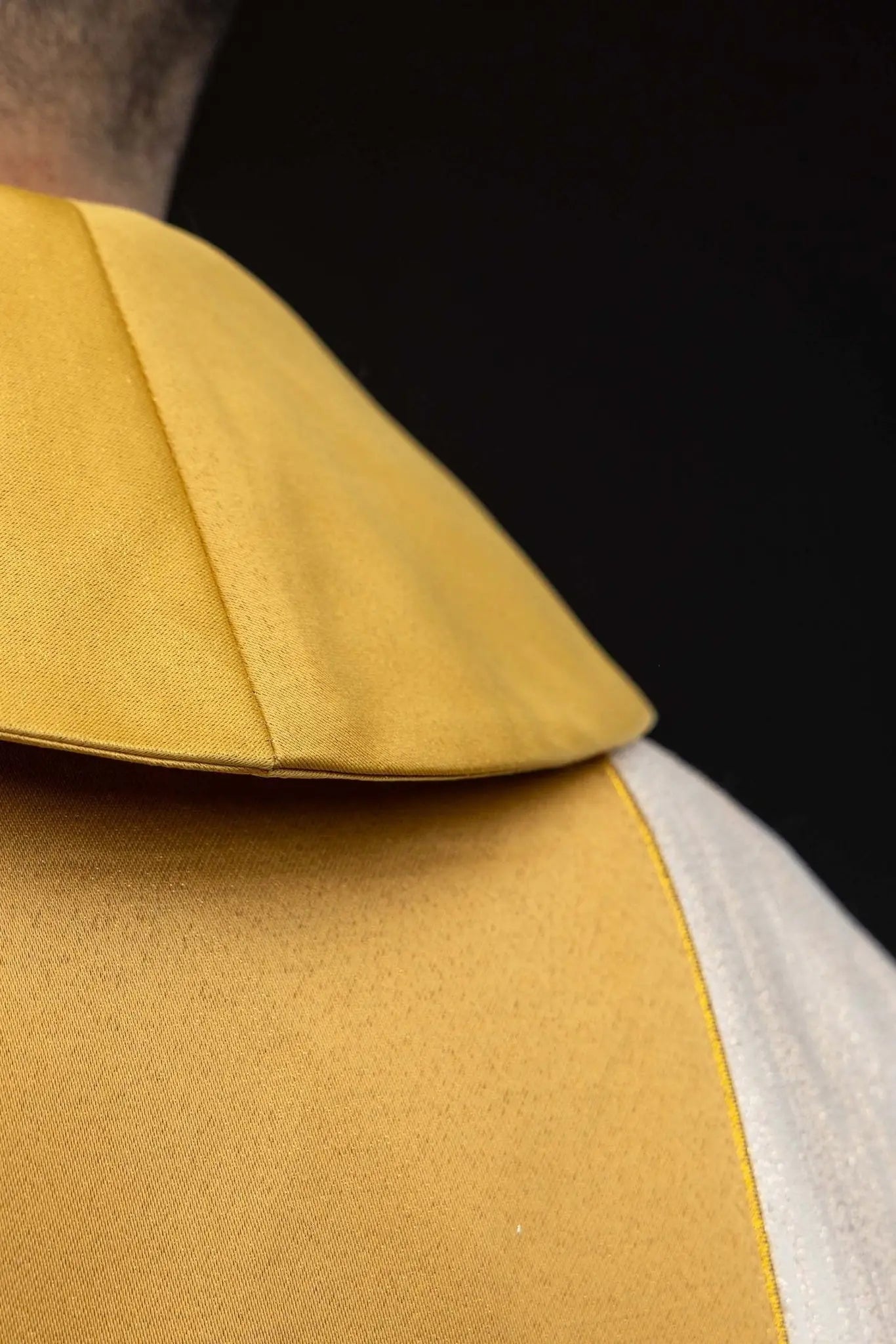 Ecru chasuble with embroidered cross motif and gold band on decorative fabric