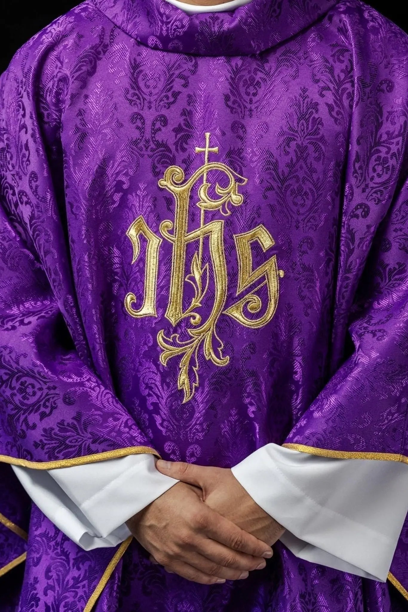 Purple chasuble with embroidered IHS motif on decorative fabric