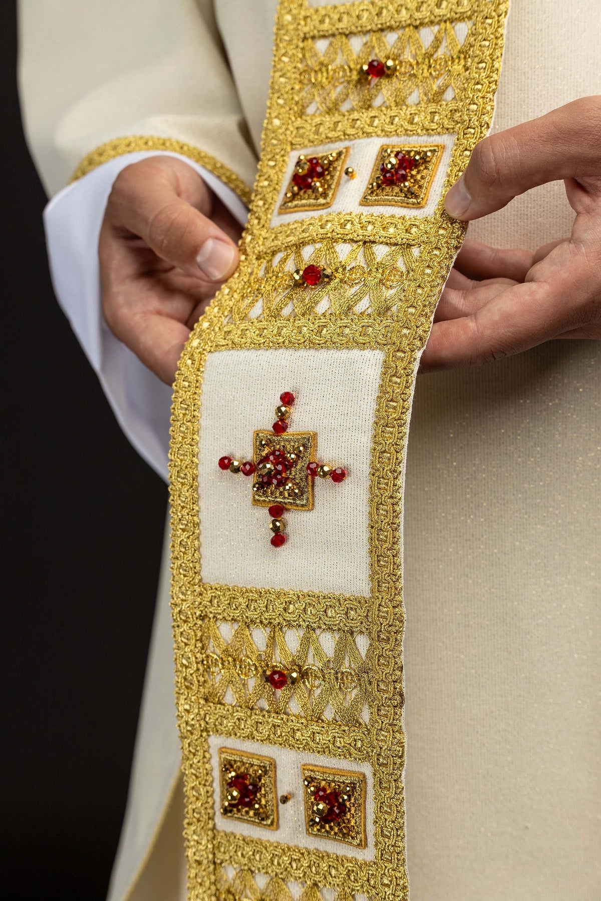 Avorio casula con ricamo dorato e due riquadri con pietre rosse, primo piano