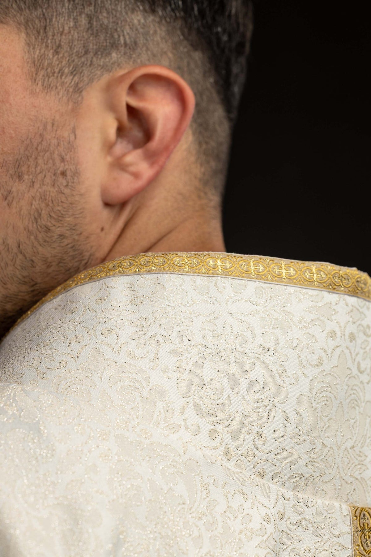 Ecru chasuble with dimensional crosses and natural stones, collar and jacquard fabric close-up