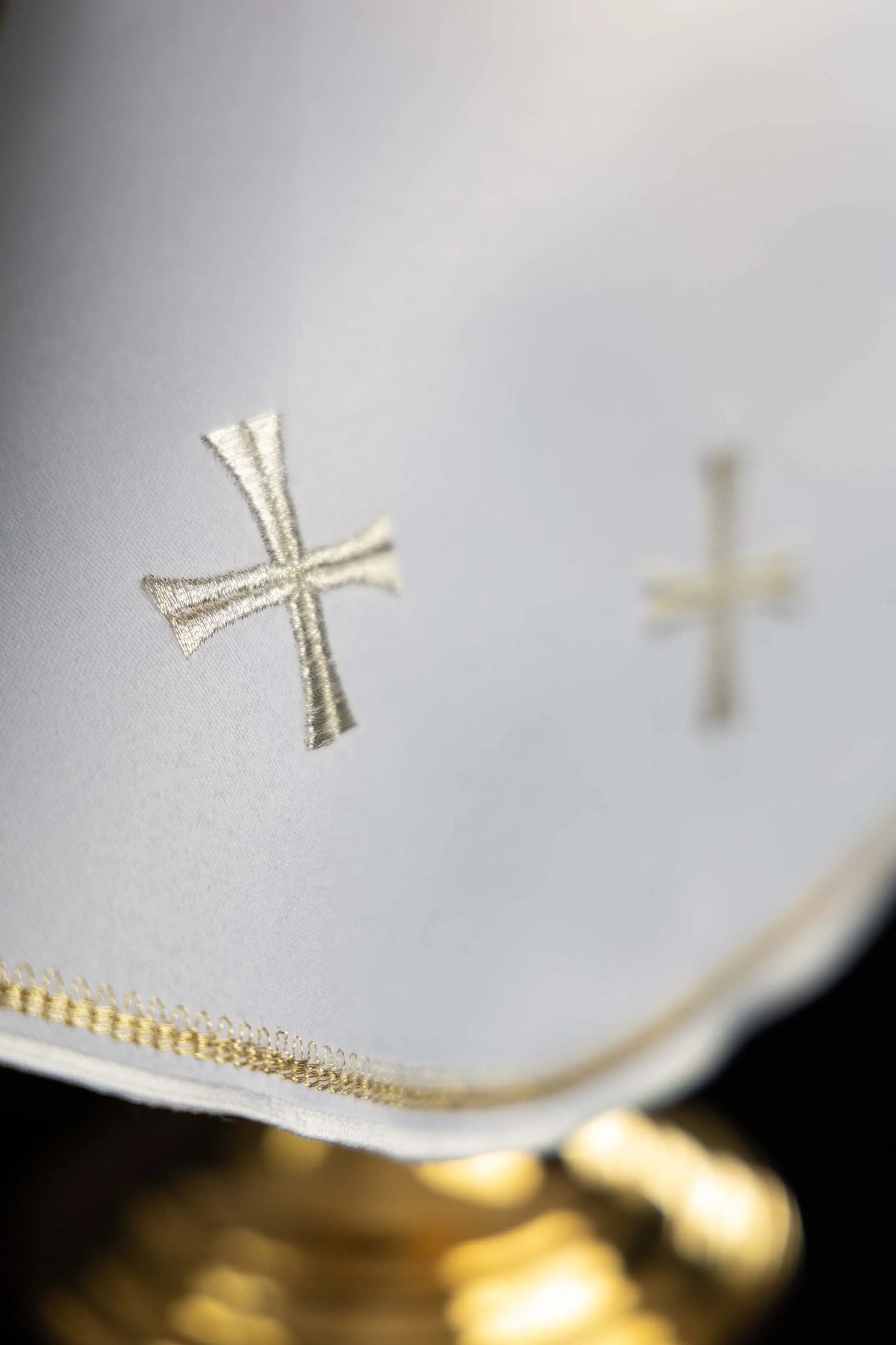 White ciborium veil with silver cross embroidery, close-up view