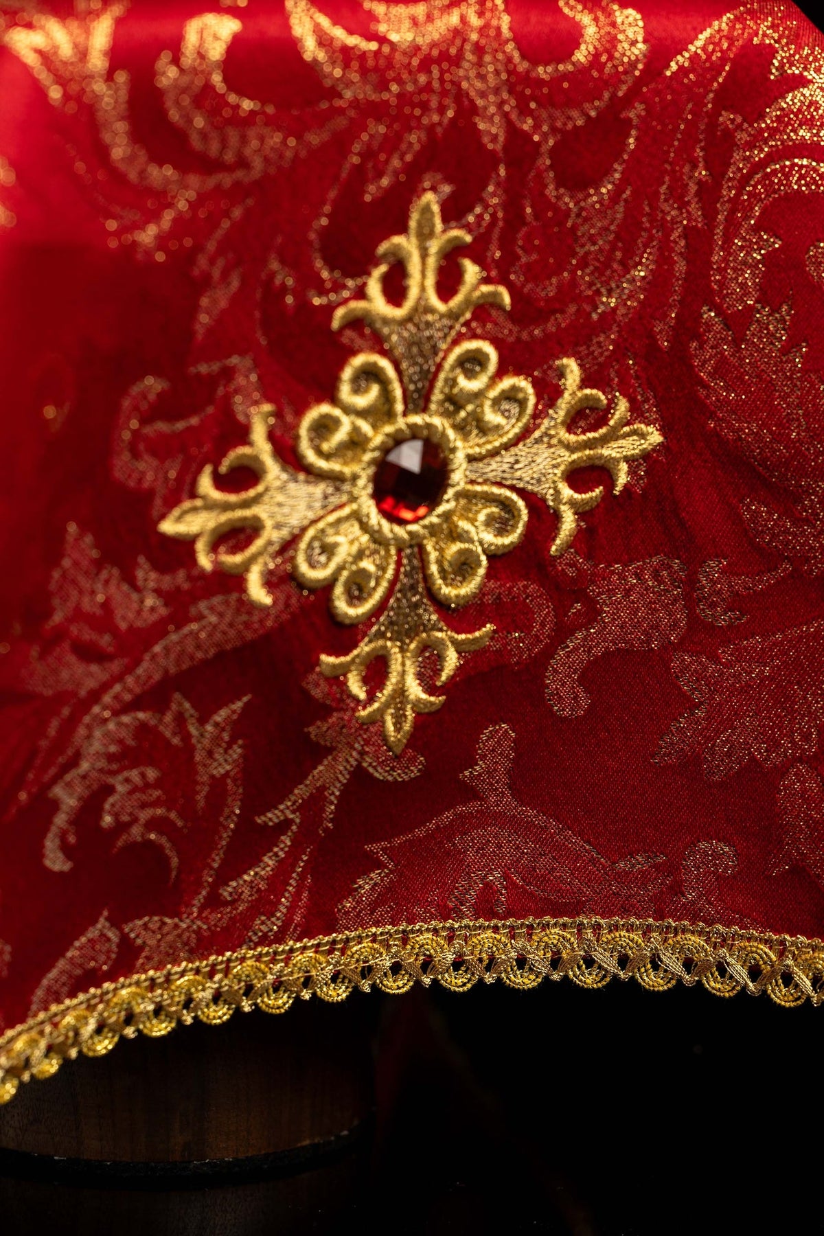 Red jacquard chalice veil with gold embroidery and cross, detail view