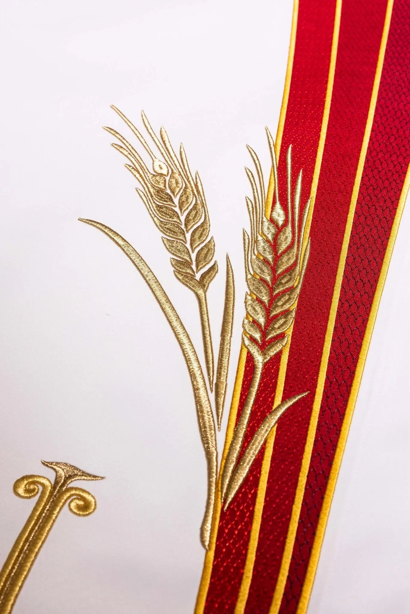 White altar cloth with embroidered Pax symbol, golden wheat sheaves, and red and gold trim