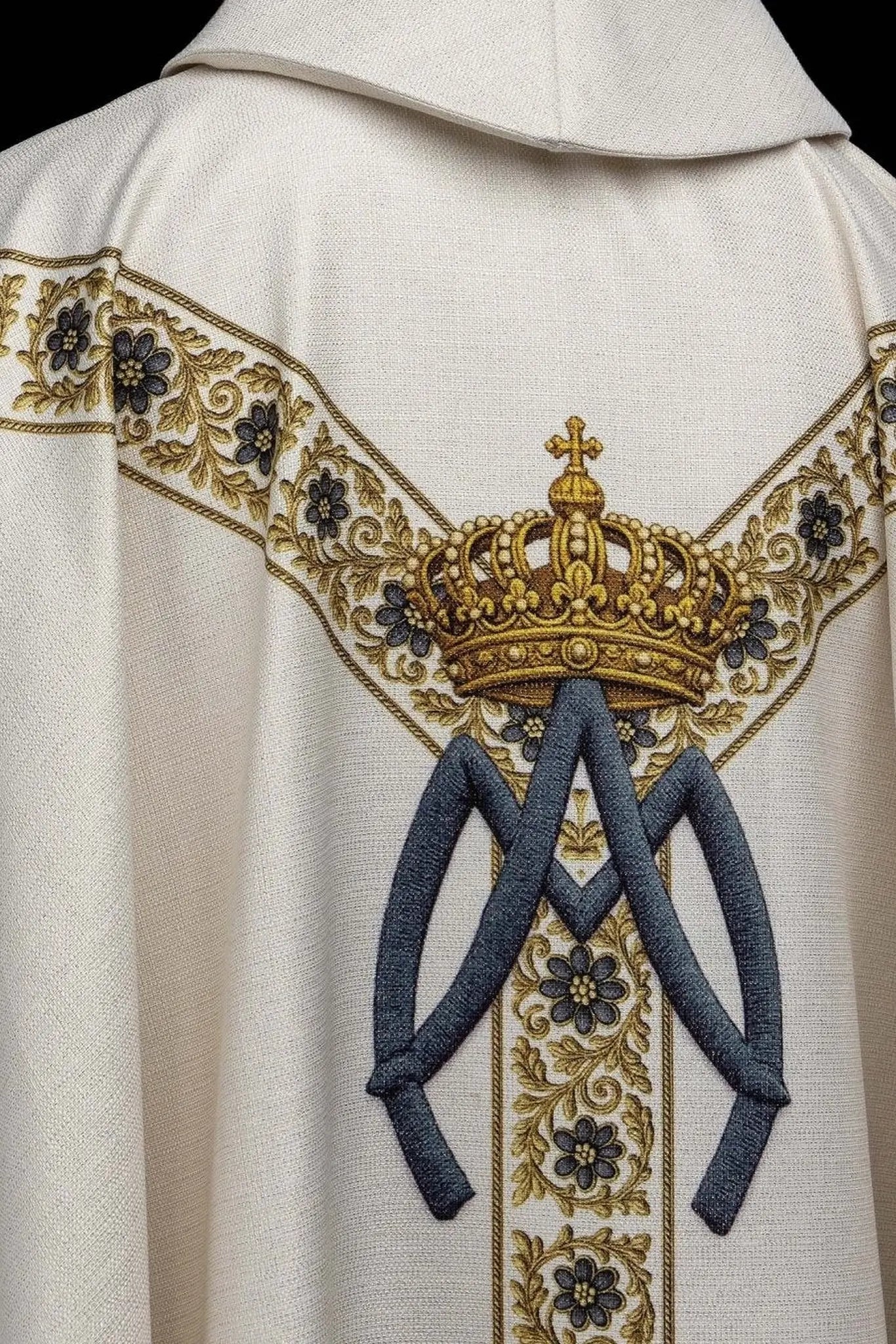 Ecru chasuble with printed image of Our Lady of Lourdes, featuring a blue sash and gold floral motifs, with a matching stole.