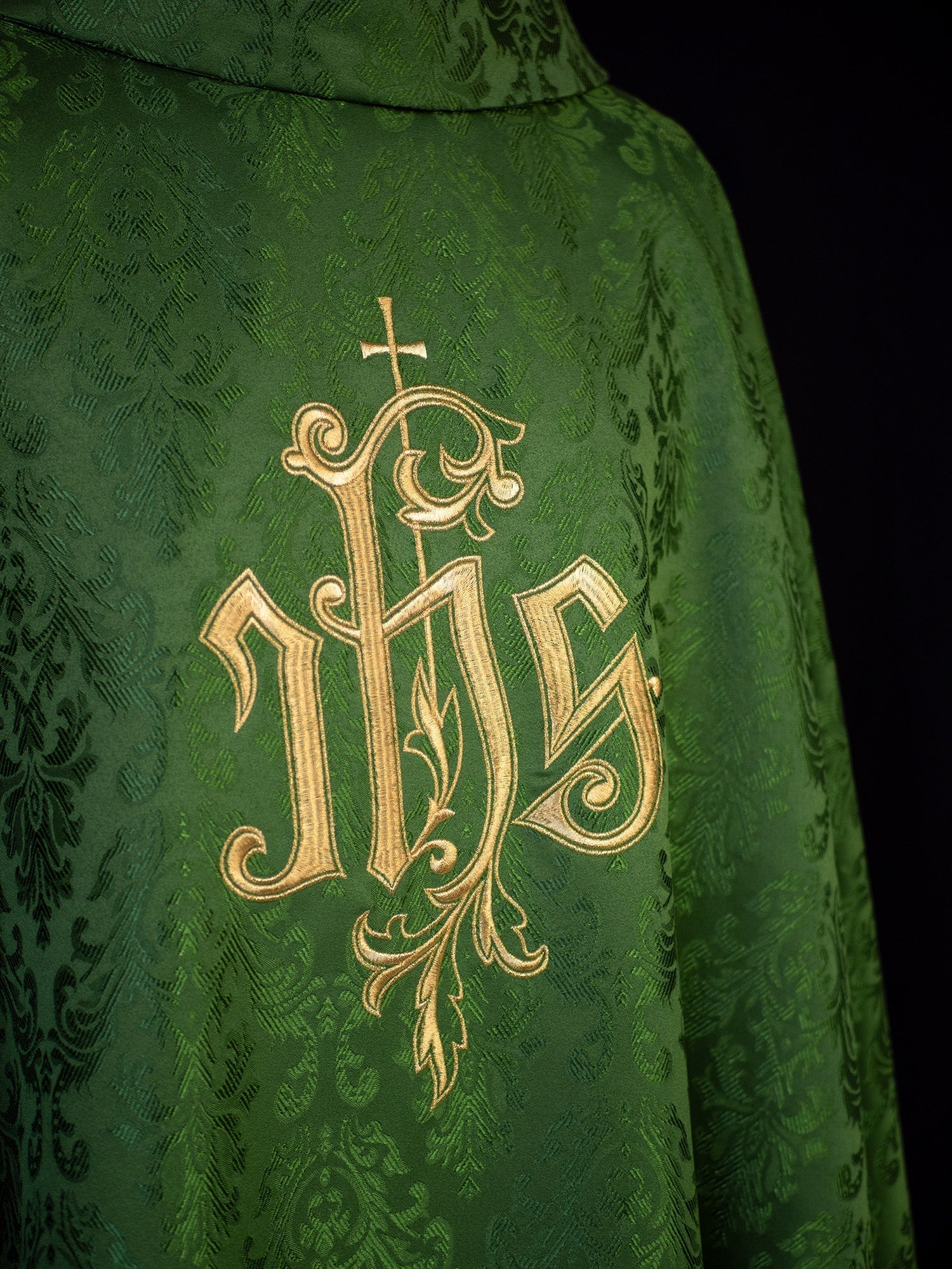 Green chasuble with embroidered IHS motif on decorative fabric