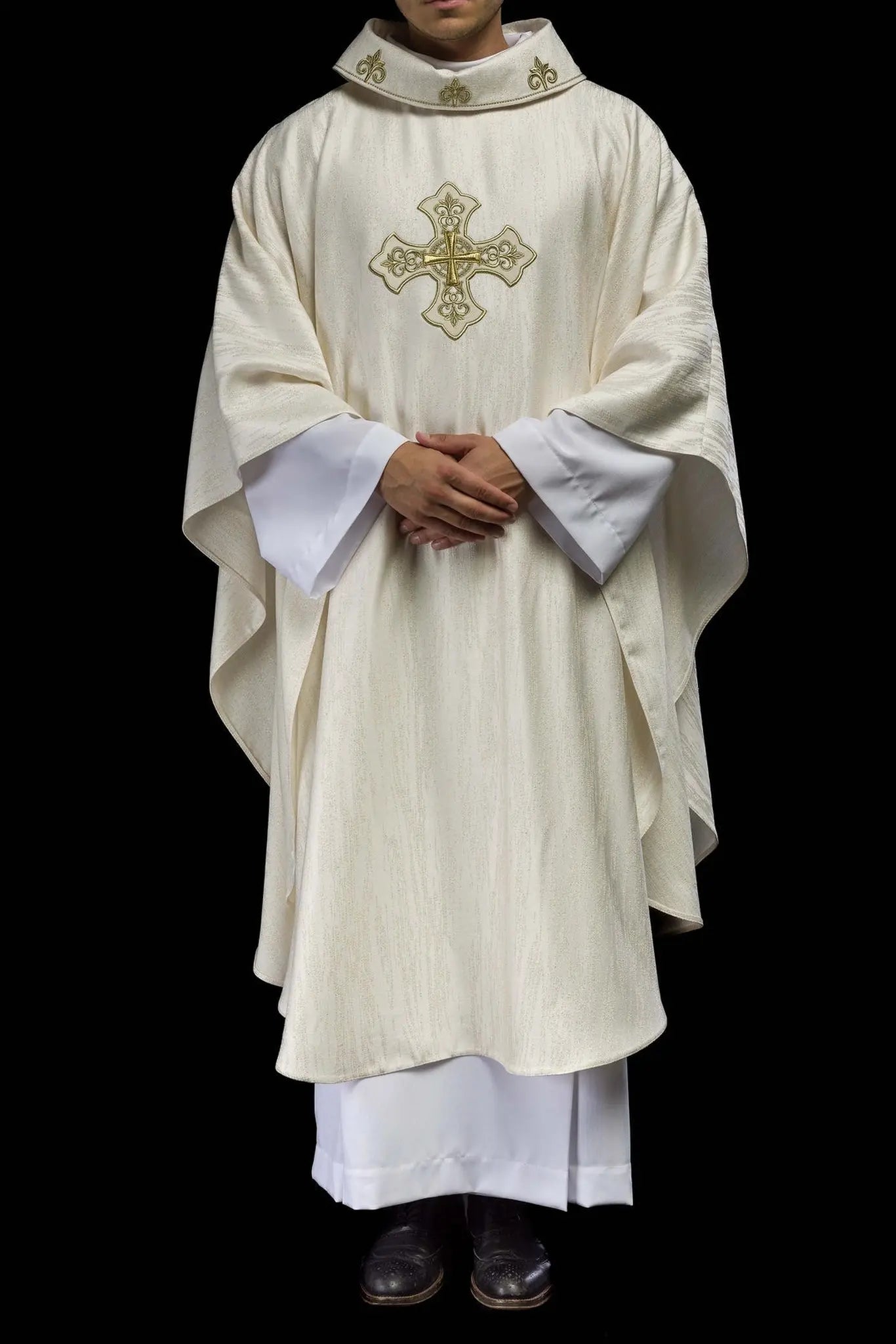 Ecru liturgical chasuble with an embroidered cross motif on decorative fabric