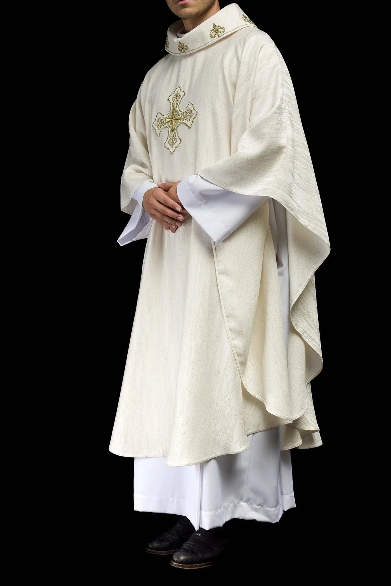 Ecru liturgical chasuble with an embroidered cross motif on decorative fabric