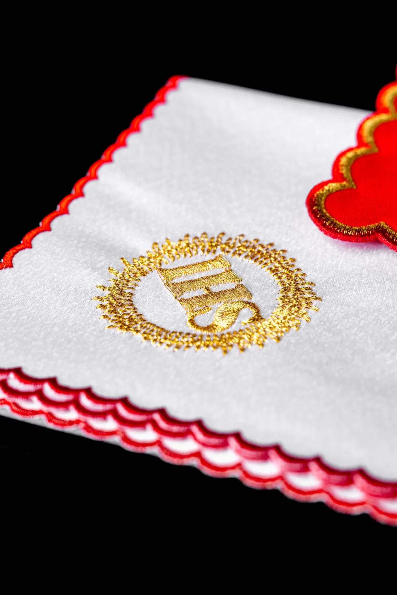 Red chalice linen set with gold IHS embroidery, including a red pall, white corporal, white purificator, and white lavabo towel, all with matching gold IHS symbols and scalloped embroidered edges.