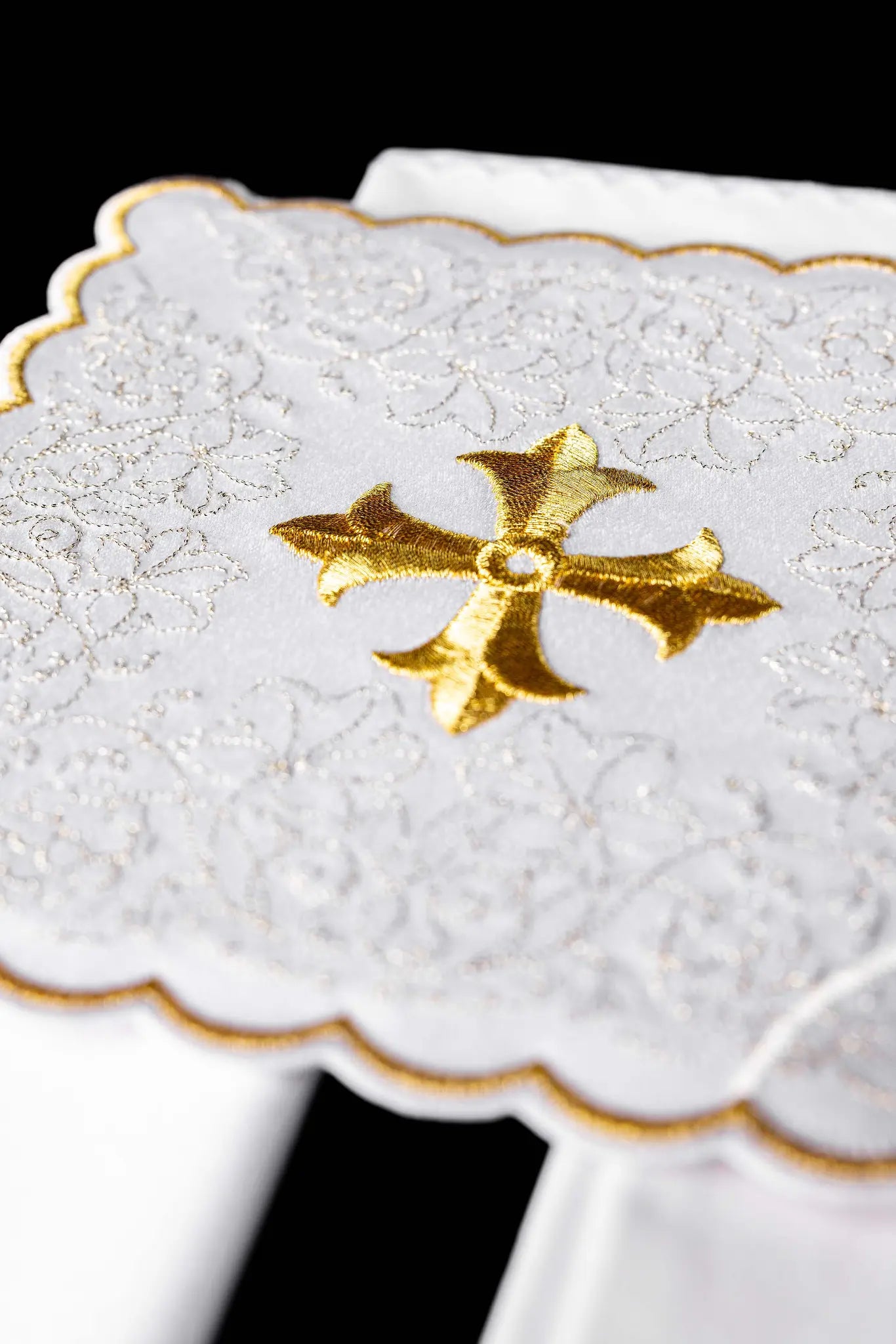 White chalice linen set with gold embroidered cross motif, including pall, corporal, purificator, and lavabo towel.