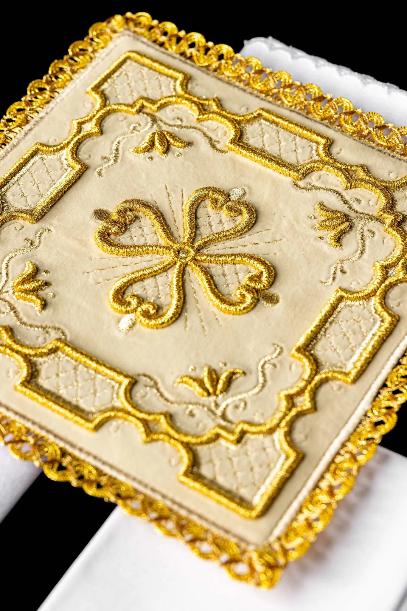Ecru chalice linen set with velvet pall, corporal, purificator, and lavabo towel. The velvet pall features a central gold embroidered rosette cross with floral and geometric patterns and gold lace trim. The purificator and lavabo towel have a small gold embroidered cross and scalloped edges.