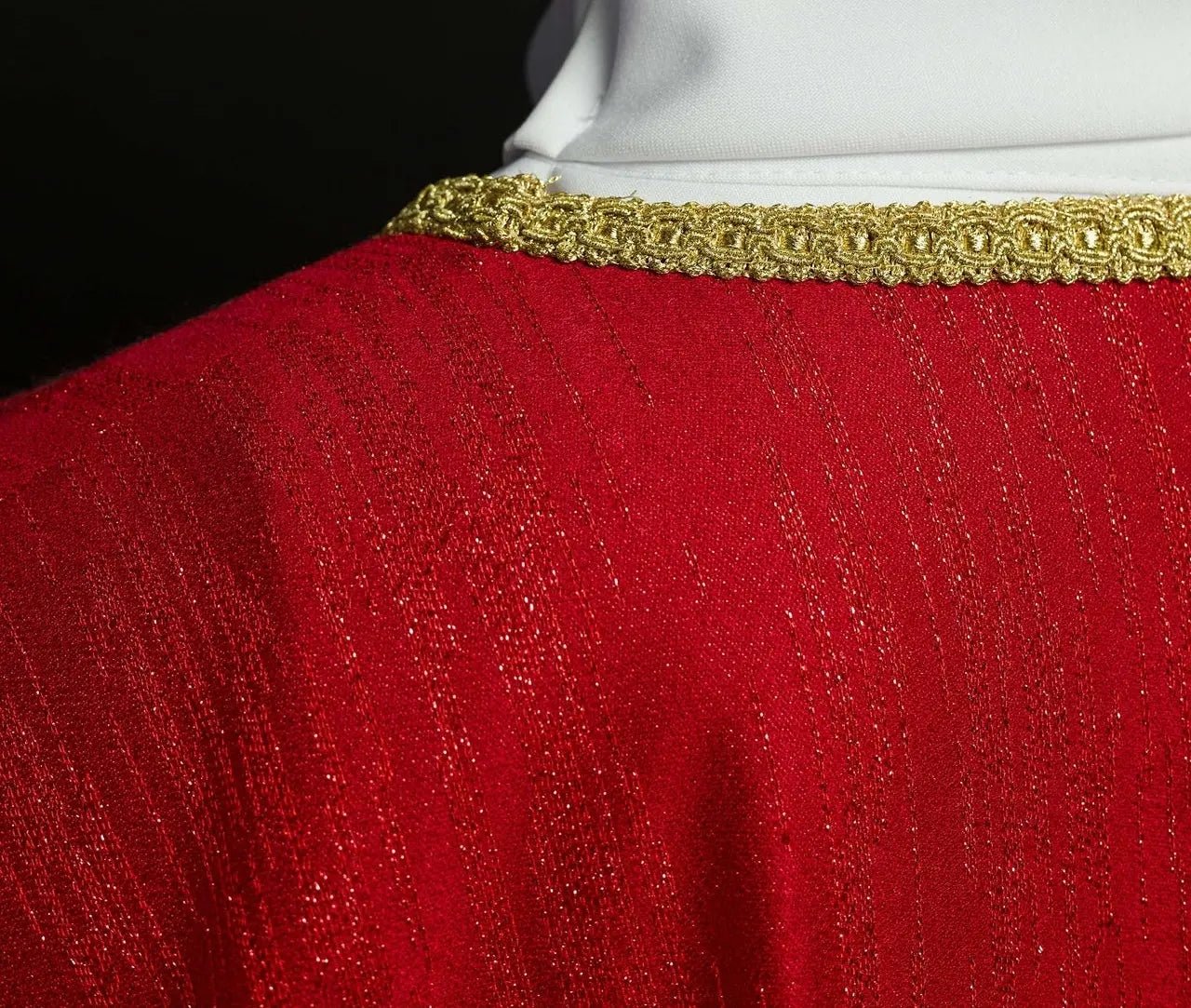 Red chasuble with embroidered cross motif on decorative fabric