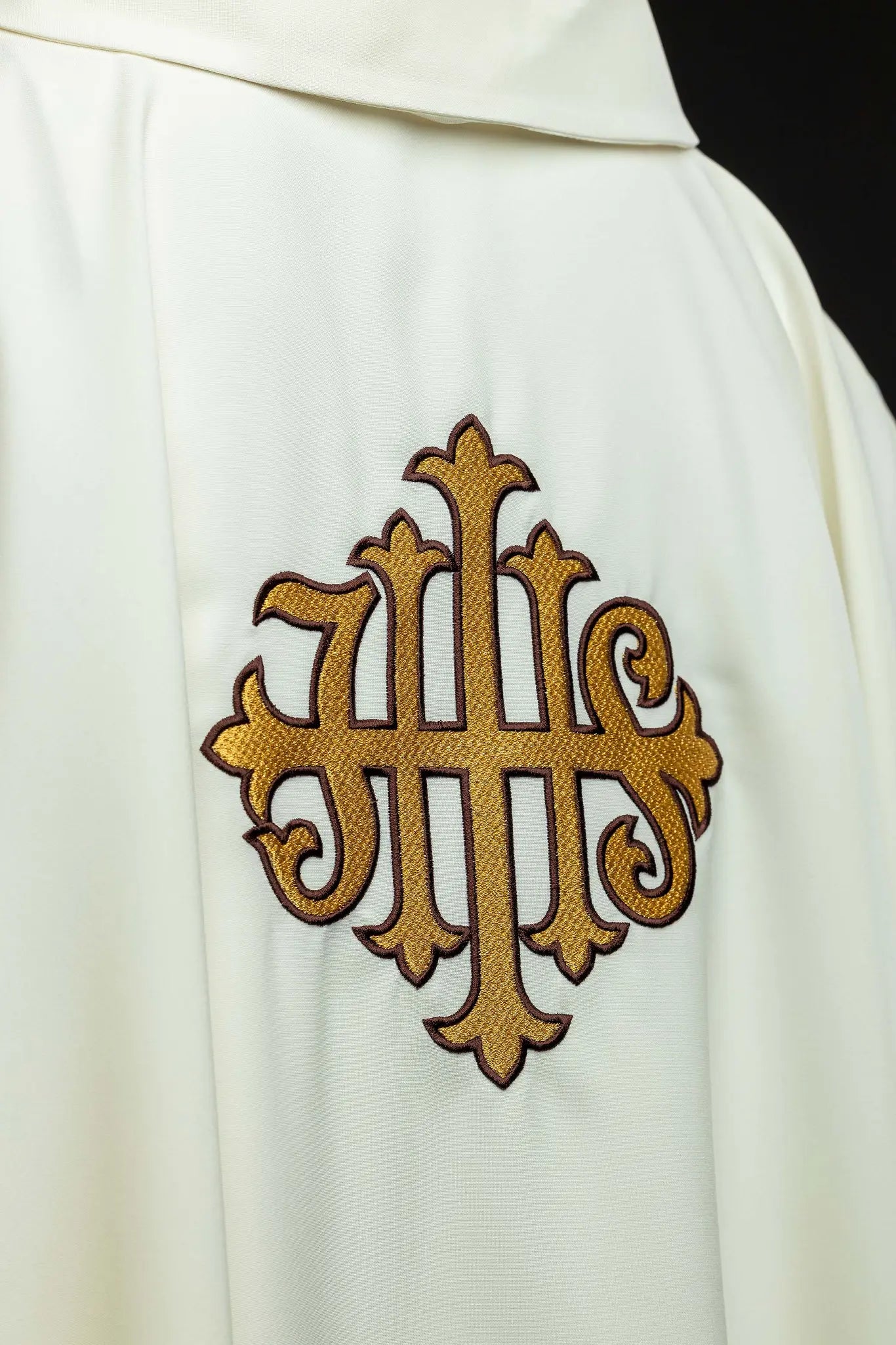 Ecru chasuble with gold IHS embroidery and gold trim, featuring a V-neck collar.