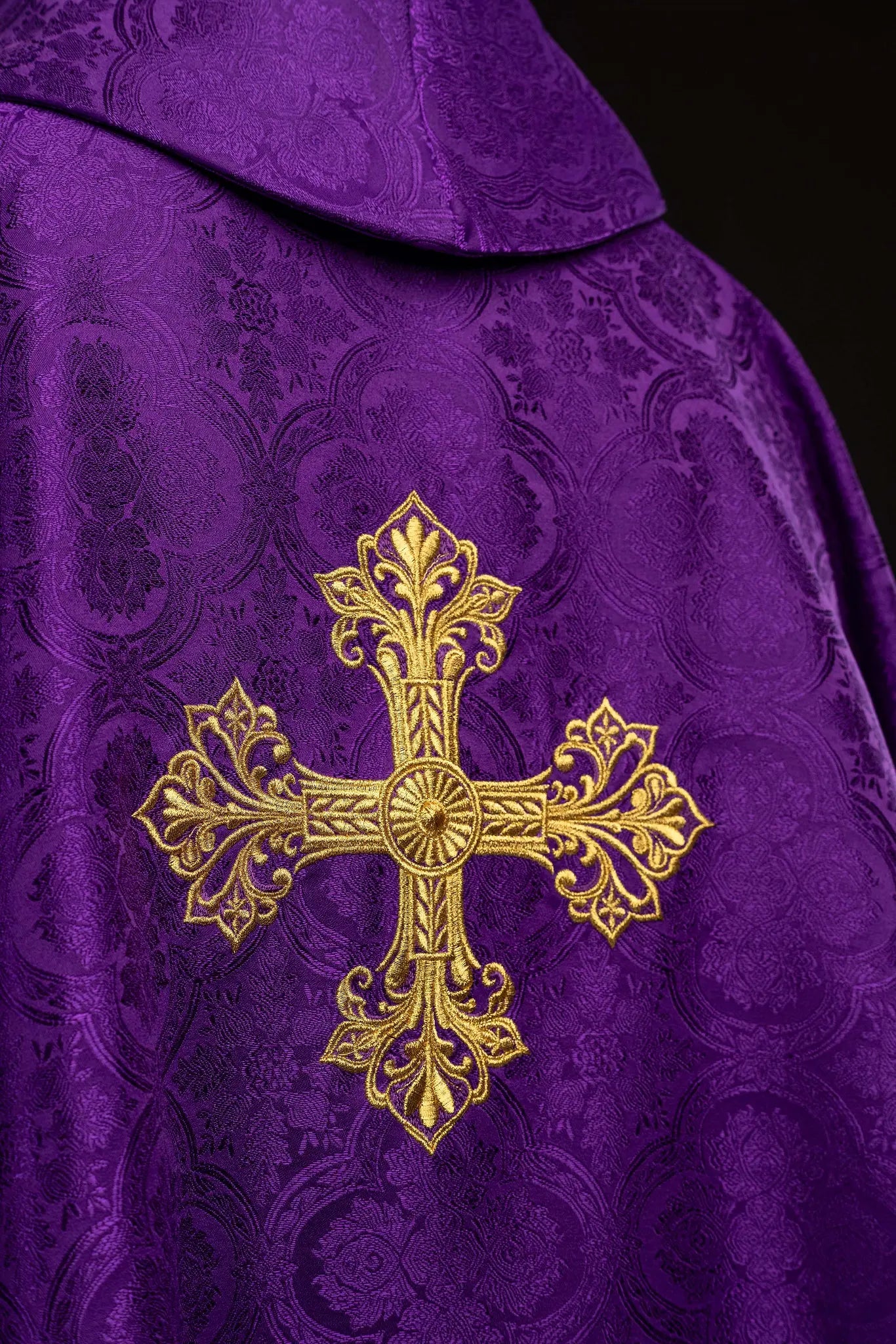 Purple chasuble with a gold embroidered cross on jacquard fabric, featuring a stand-up collar and gold trim.