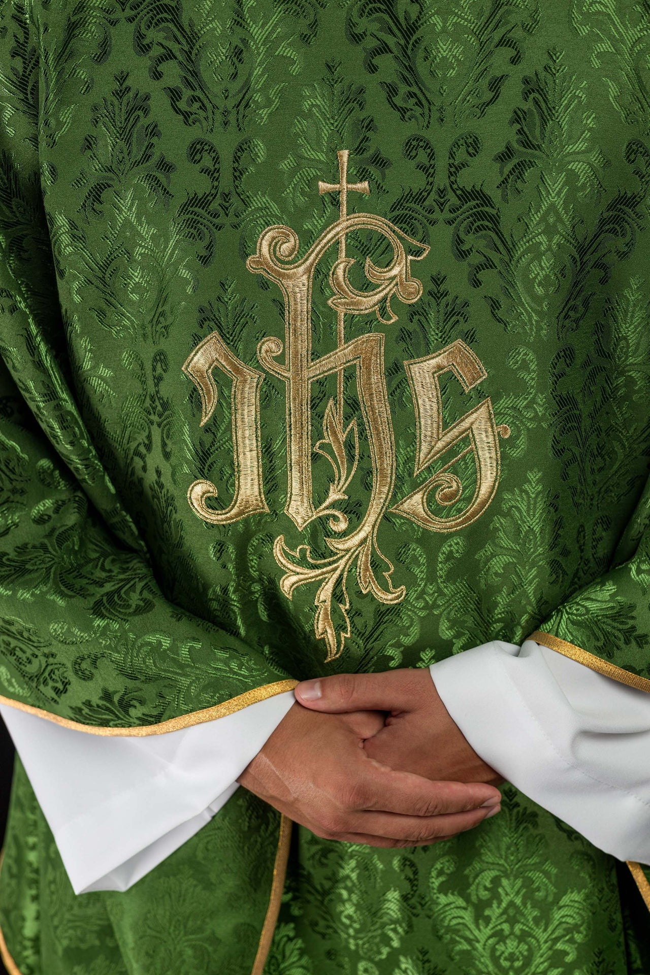 Green chasuble with embroidered IHS motif on decorative fabric