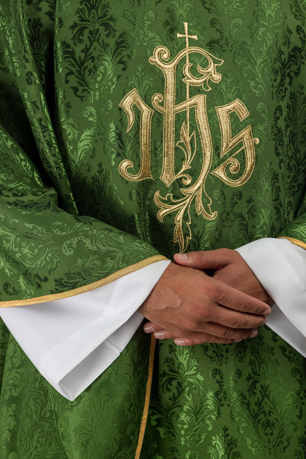 Green chasuble with embroidered IHS motif on decorative fabric