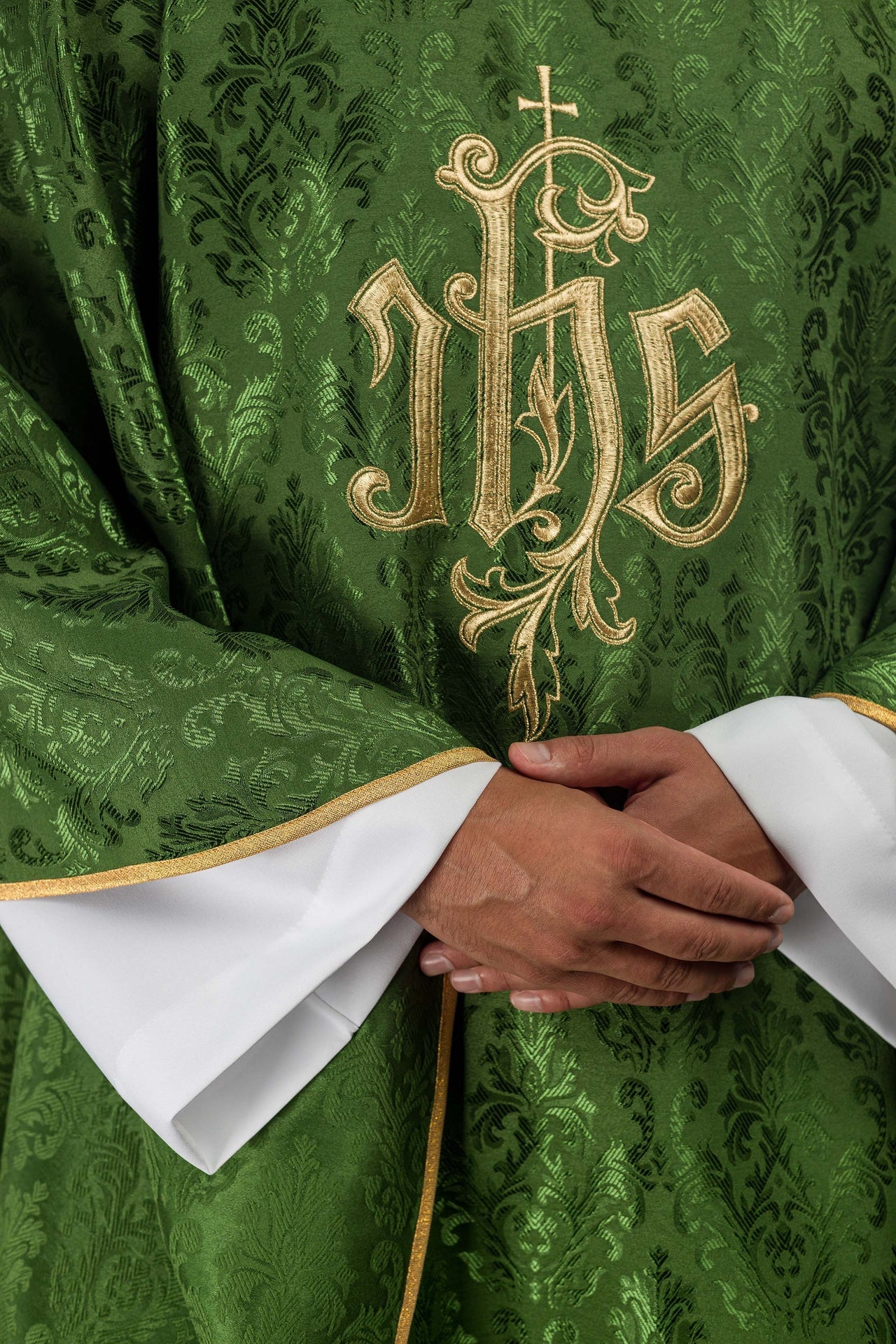 Green chasuble with embroidered IHS motif on decorative fabric
