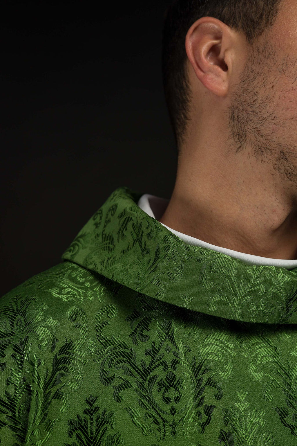 Green chasuble with embroidered IHS motif on decorative fabric