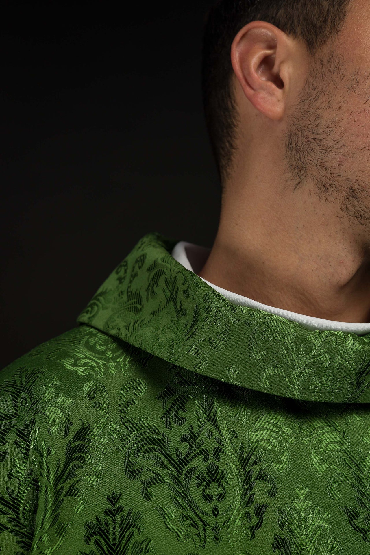 Green chasuble with embroidered IHS motif on decorative fabric