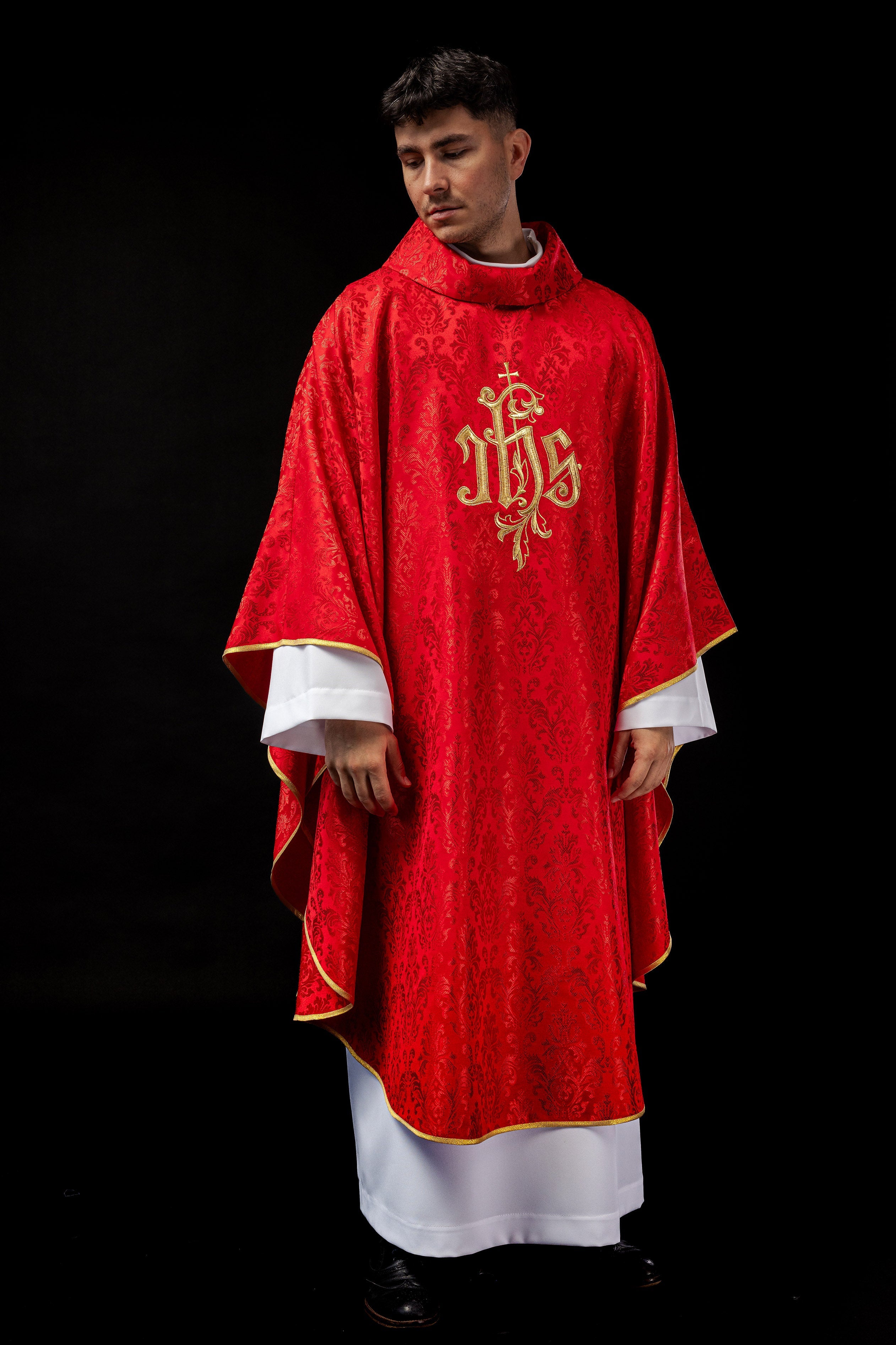 Red chasuble with embroidered IHS motif on decorative fabric