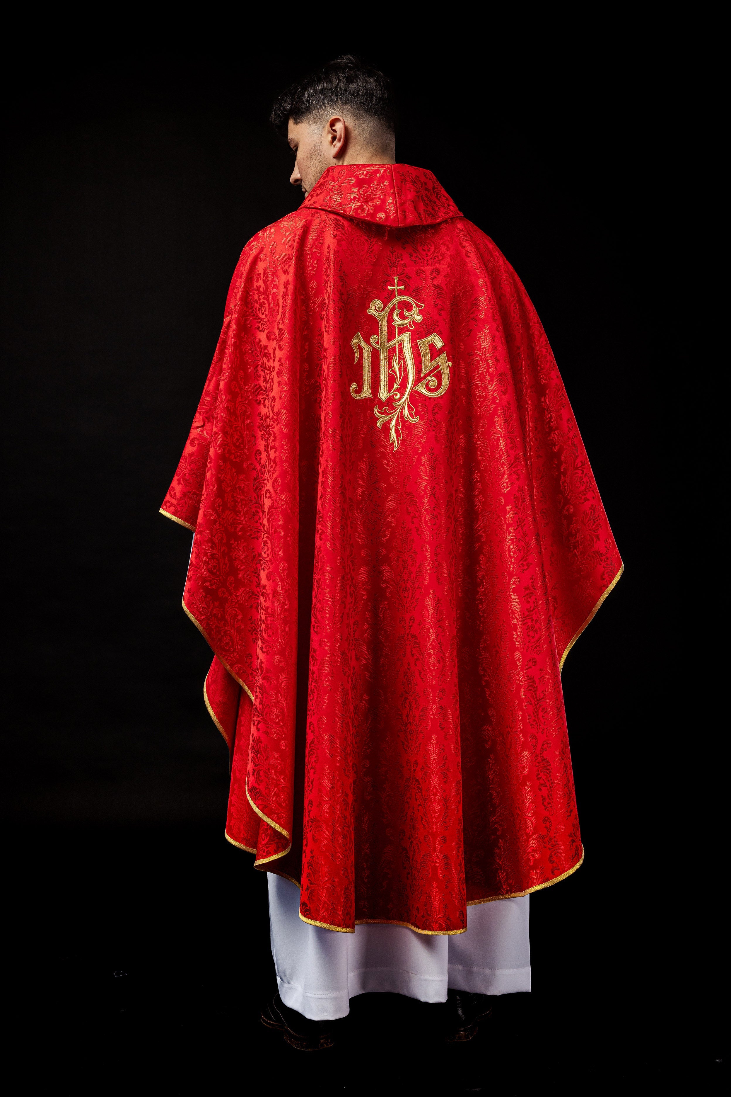 Red chasuble with embroidered IHS motif on decorative fabric