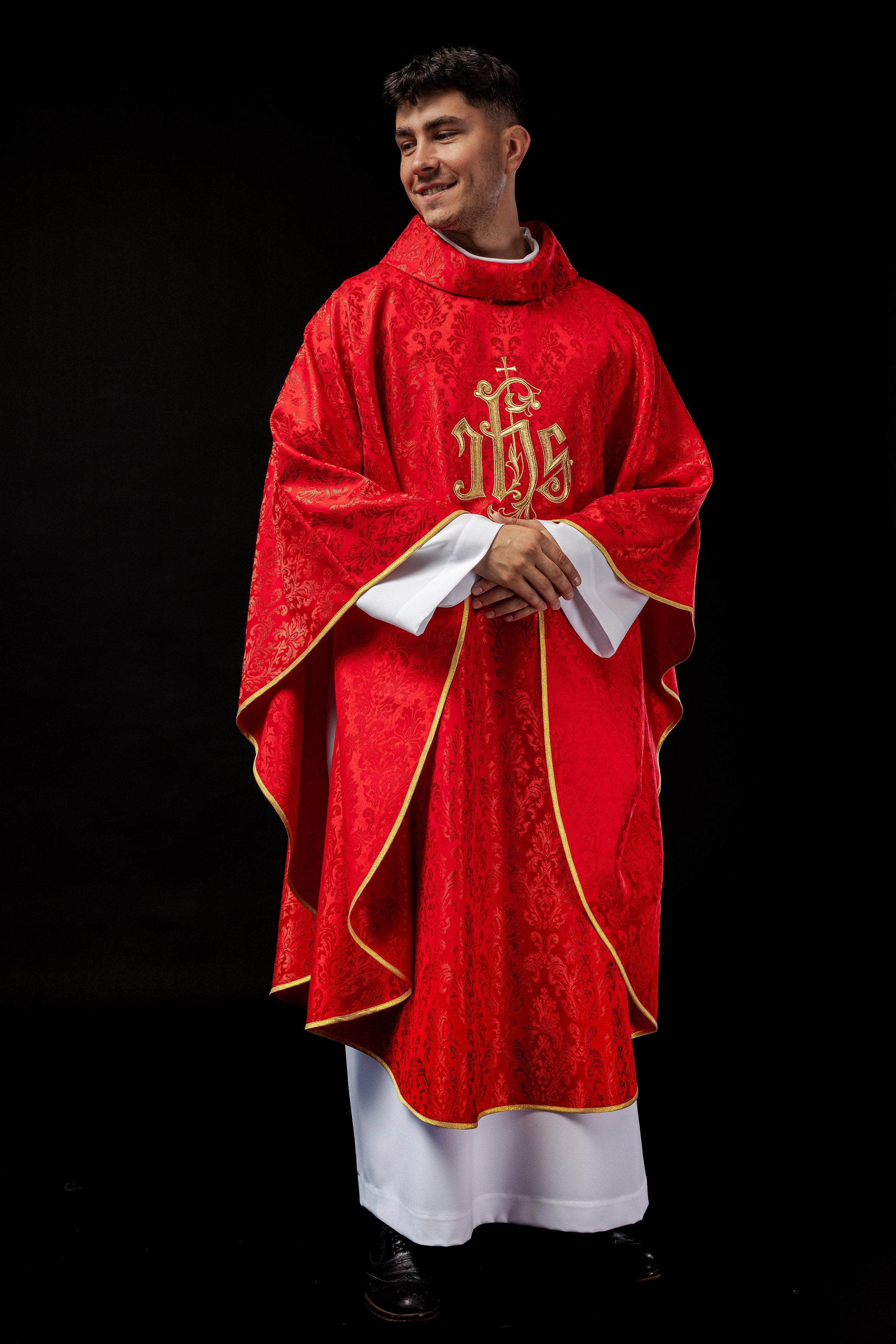 Red chasuble with embroidered IHS motif on decorative fabric