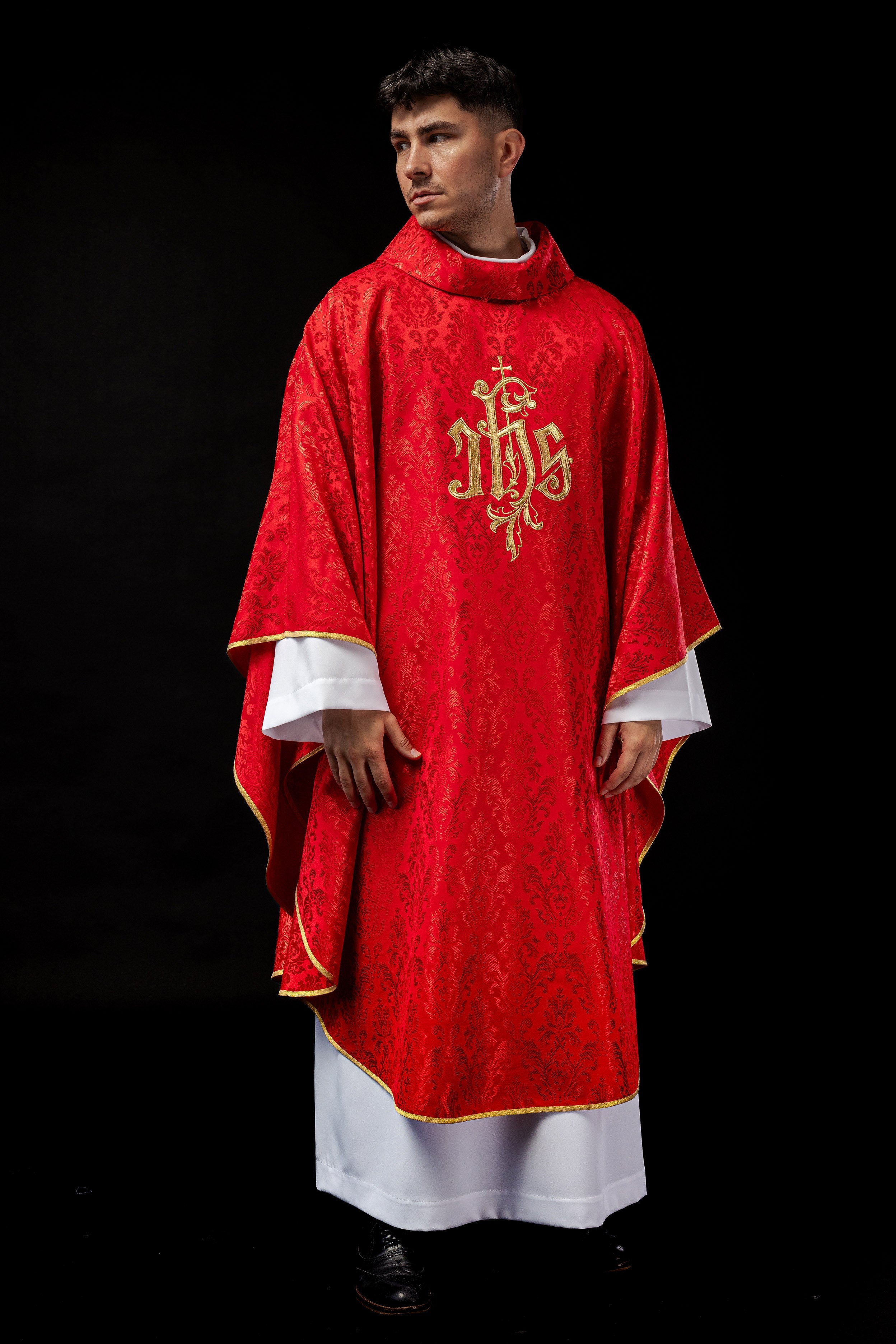 Red chasuble with embroidered IHS motif on decorative fabric