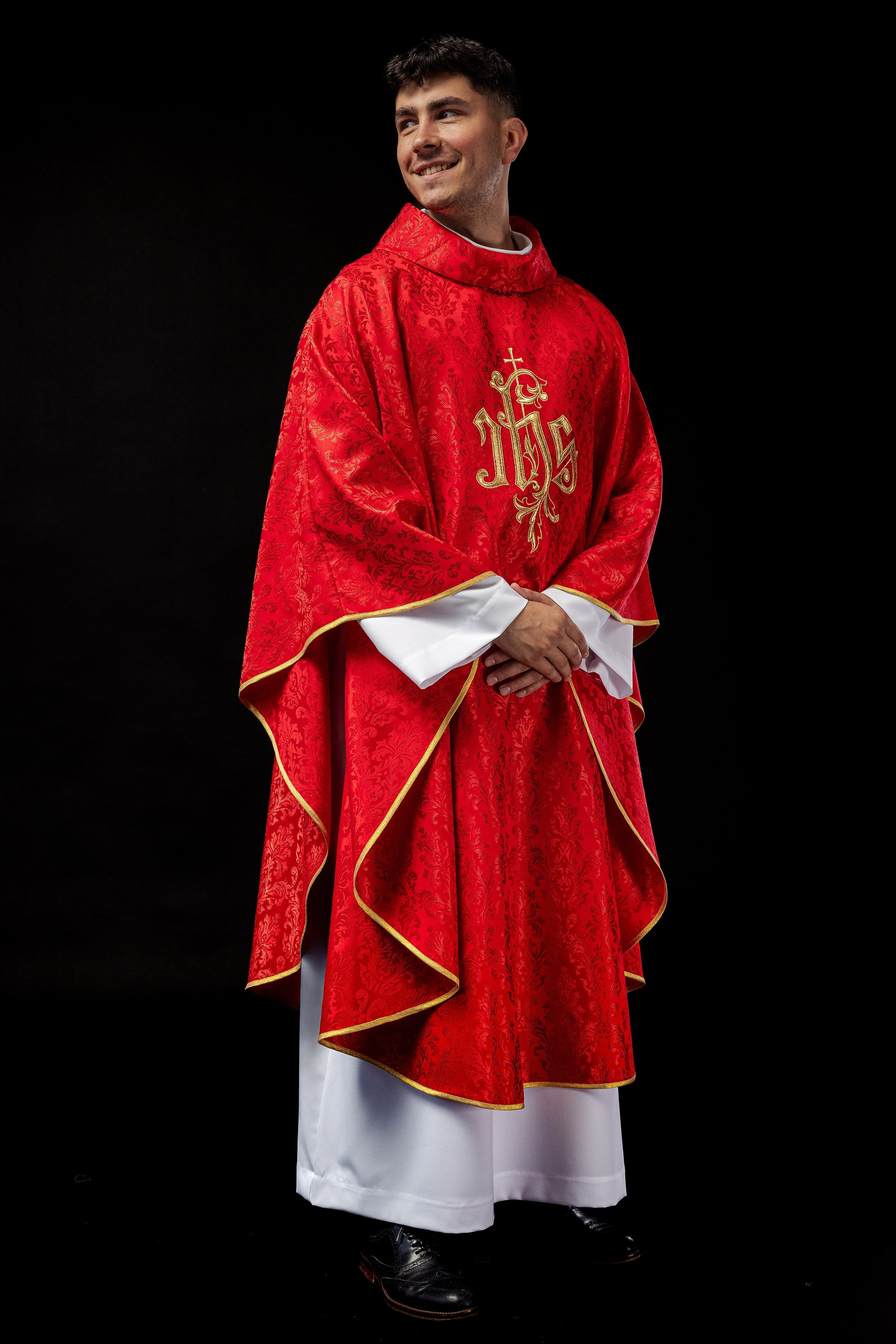 Red chasuble with embroidered IHS motif on decorative fabric