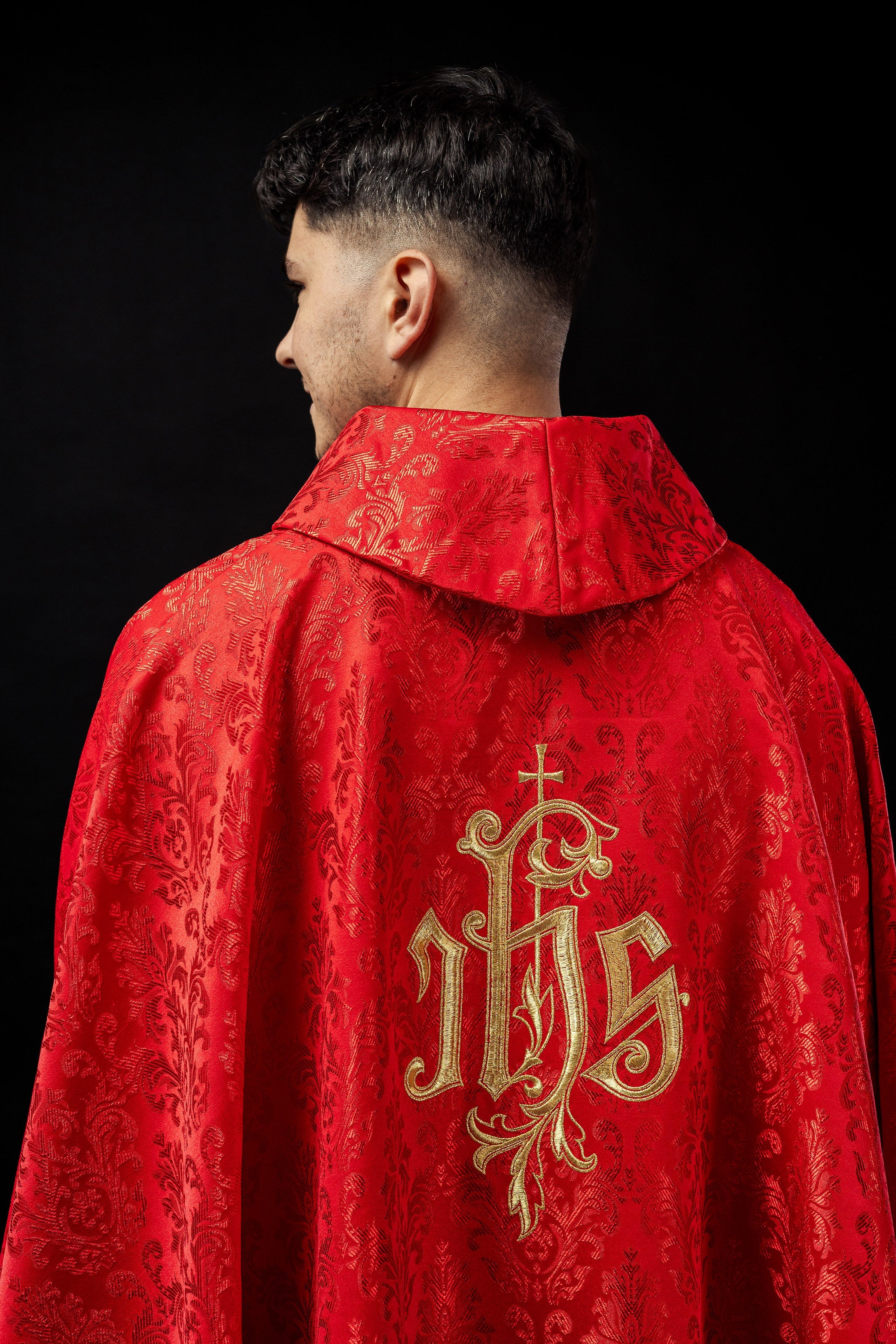 Red chasuble with embroidered IHS motif on decorative fabric