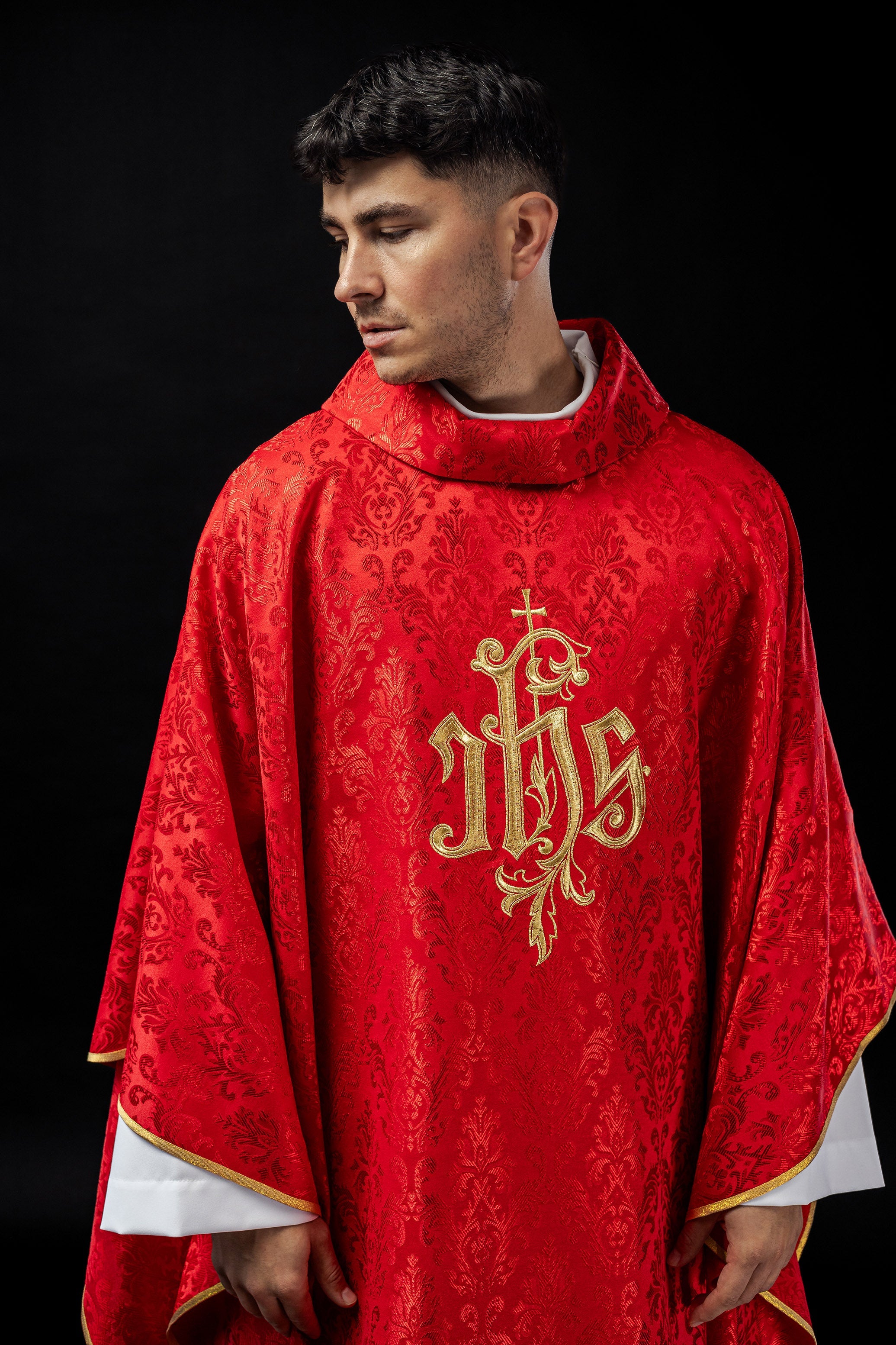 Red chasuble with embroidered IHS motif on decorative fabric