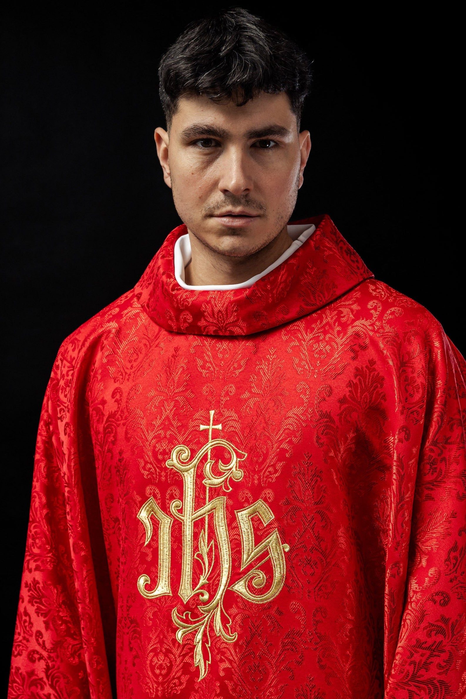 Red chasuble with embroidered IHS motif on decorative fabric