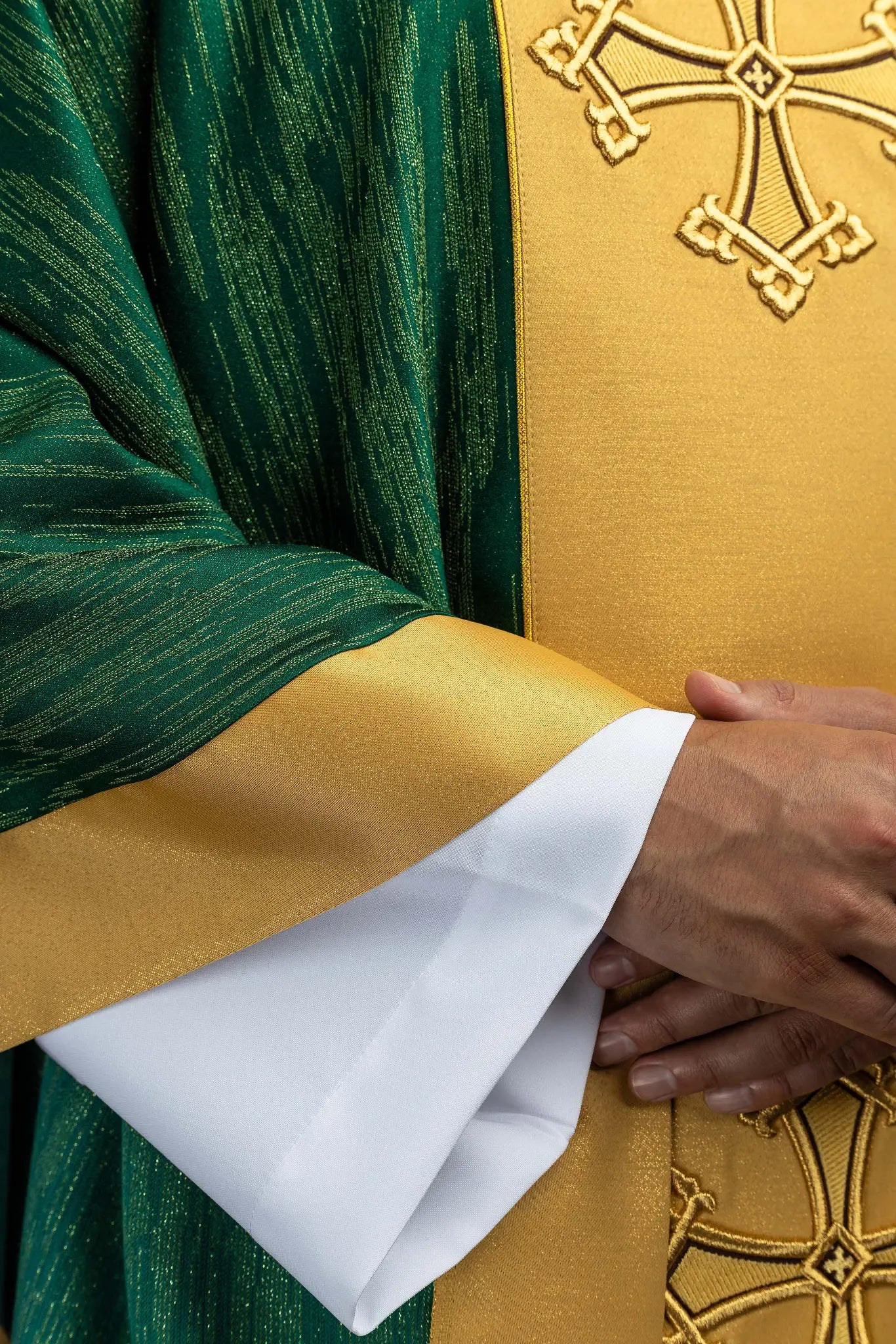 Green chasuble with a vertical gold band featuring embroidered crosses, gold trim on edges and collar, and a stand-up collar.