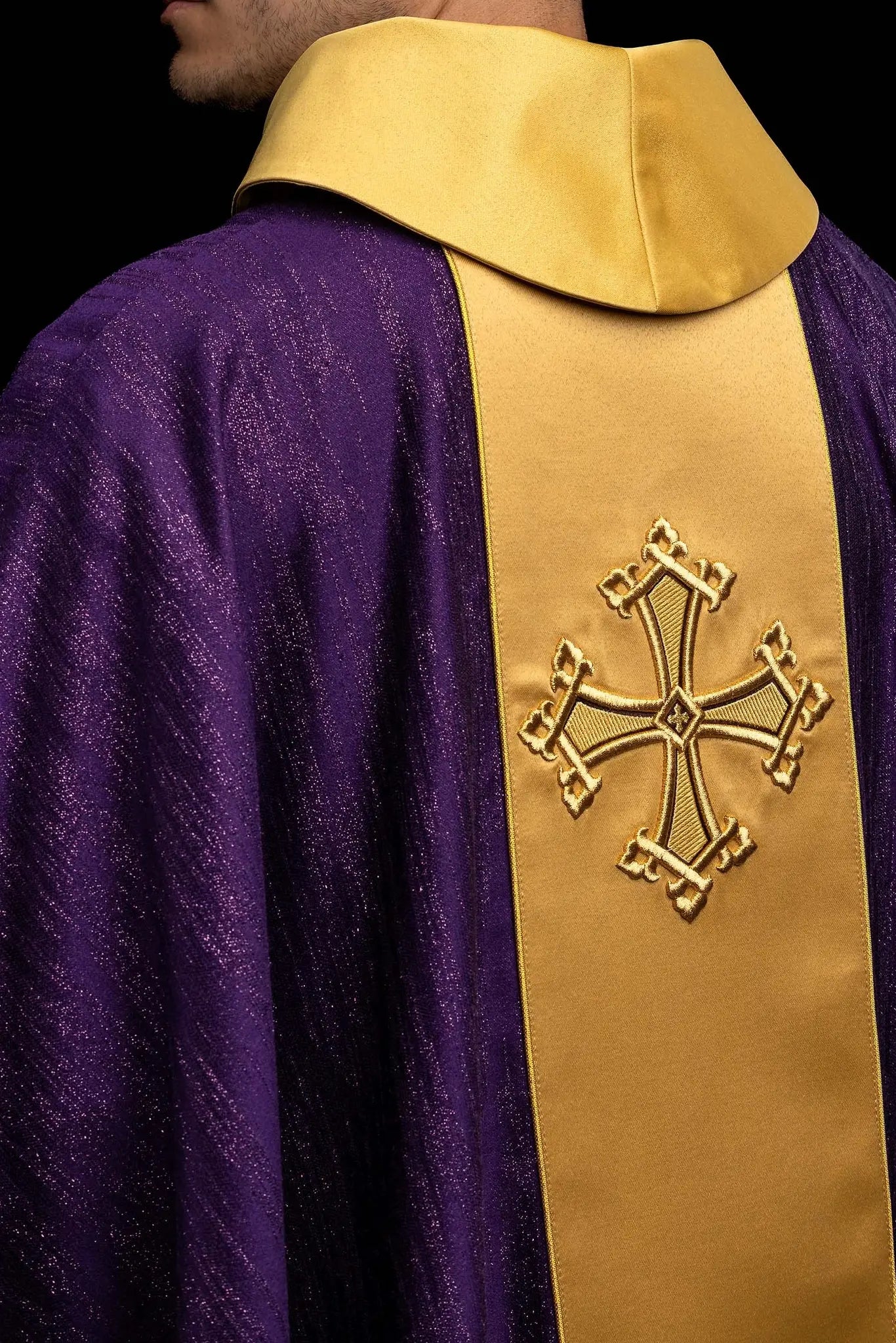 Purple chasuble with a vertical gold band featuring embroidered stylized crosses, gold trim on sleeves and collar, and a stand-up collar.