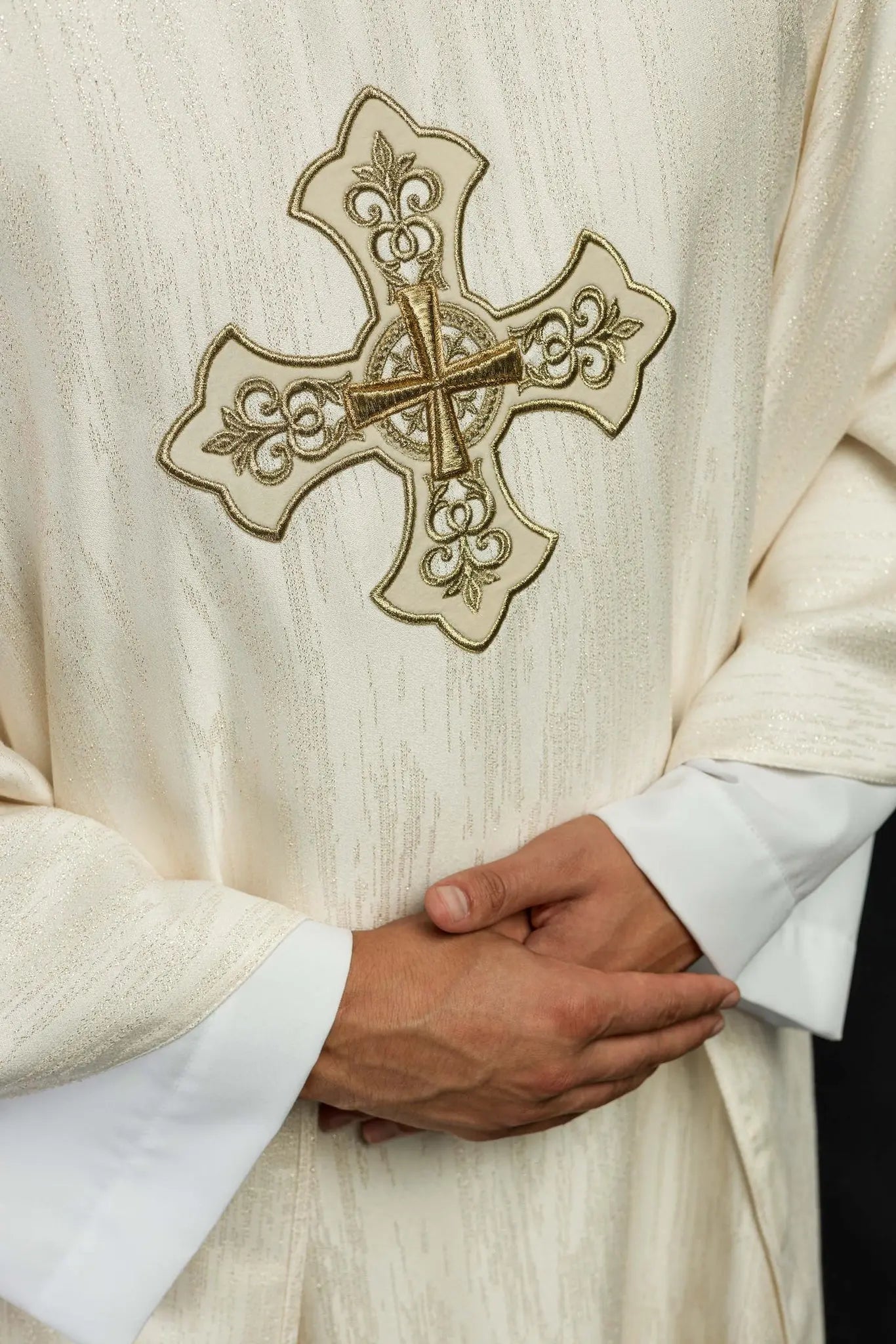 Ecru liturgical chasuble with an embroidered cross motif on decorative fabric