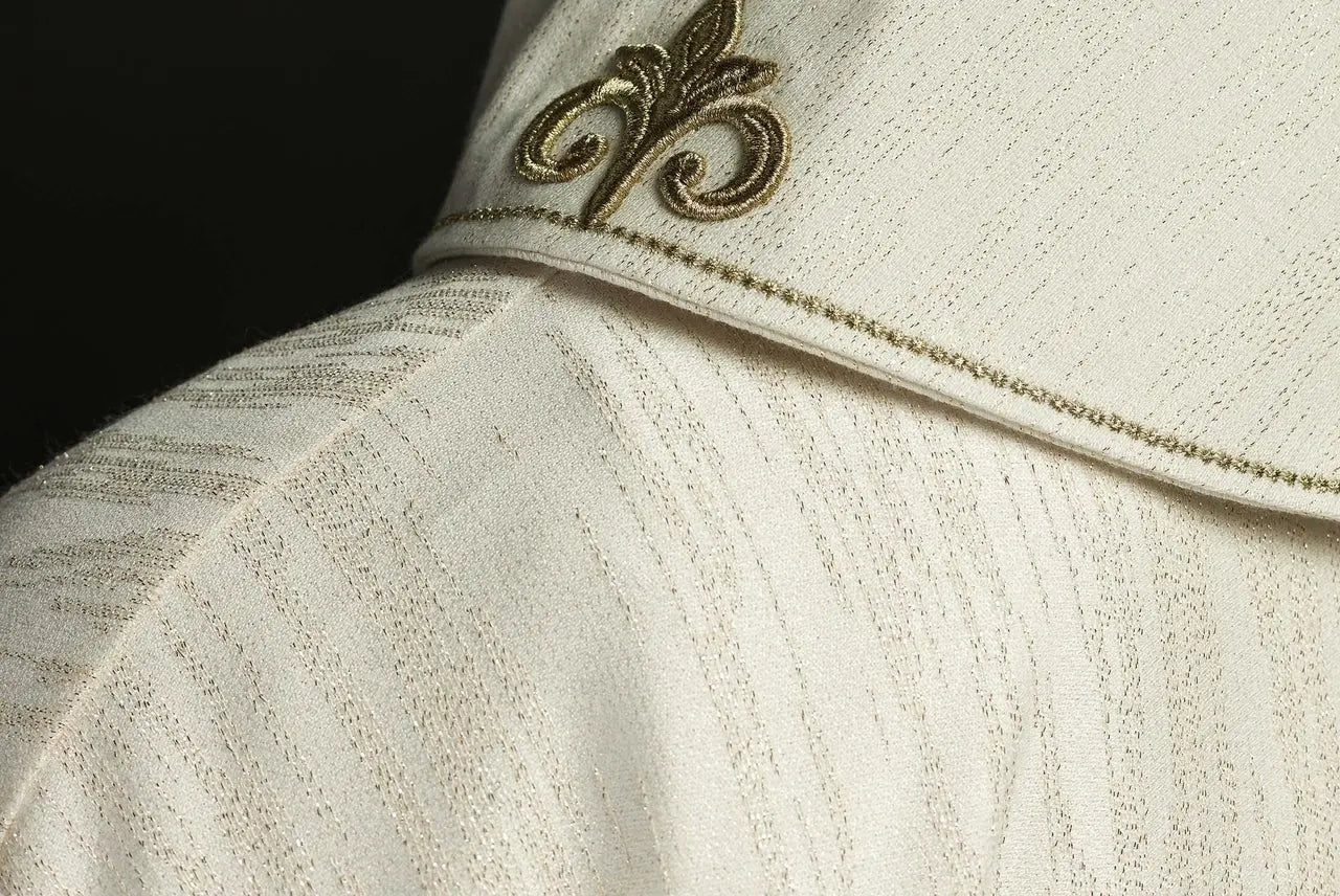 Ecru liturgical chasuble with an embroidered cross motif on decorative fabric