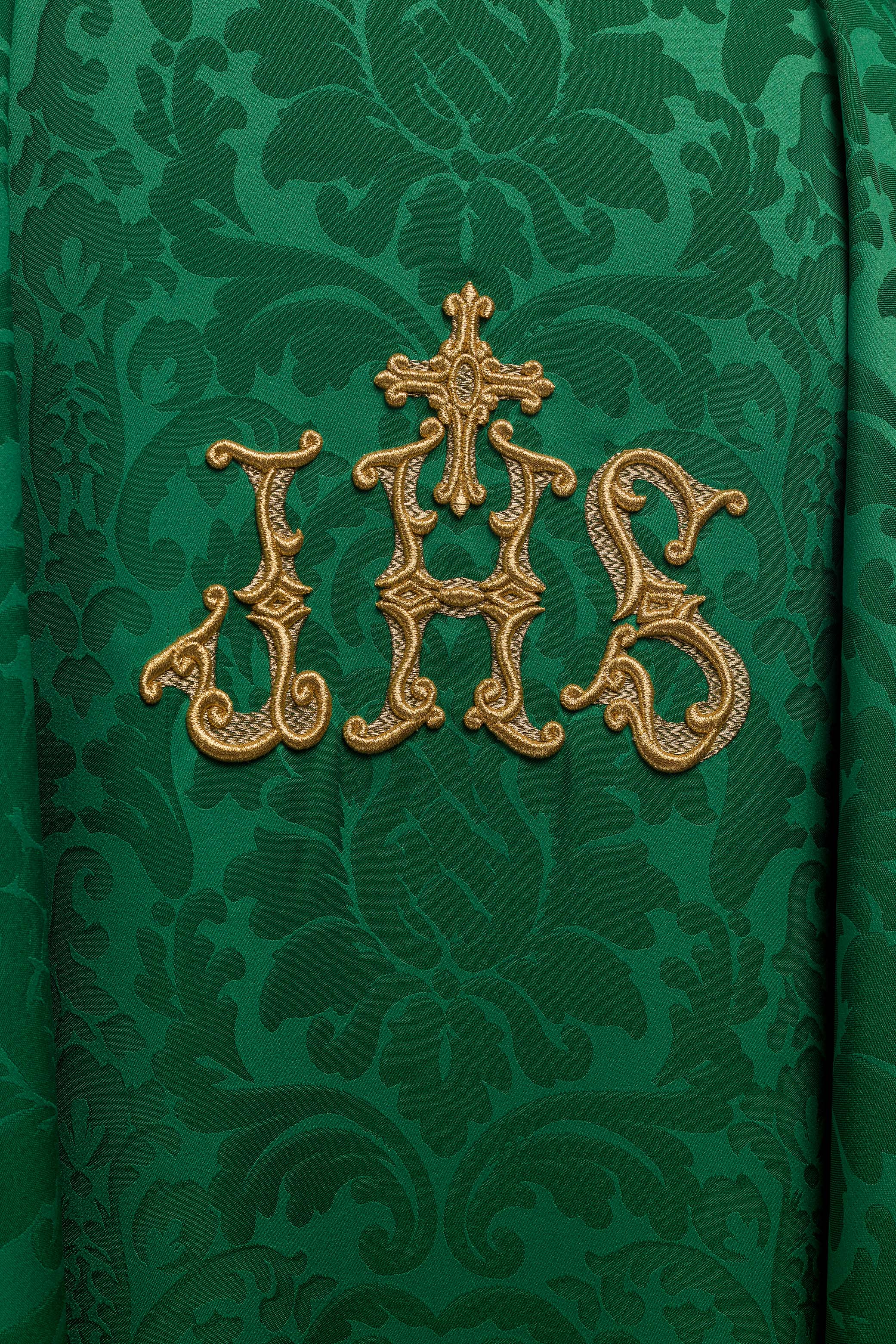 Green chasuble with IHS motif and richly embroidered collar on decorative fabric