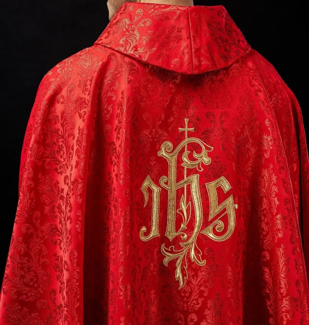 Red chasuble with embroidered IHS motif on decorative fabric