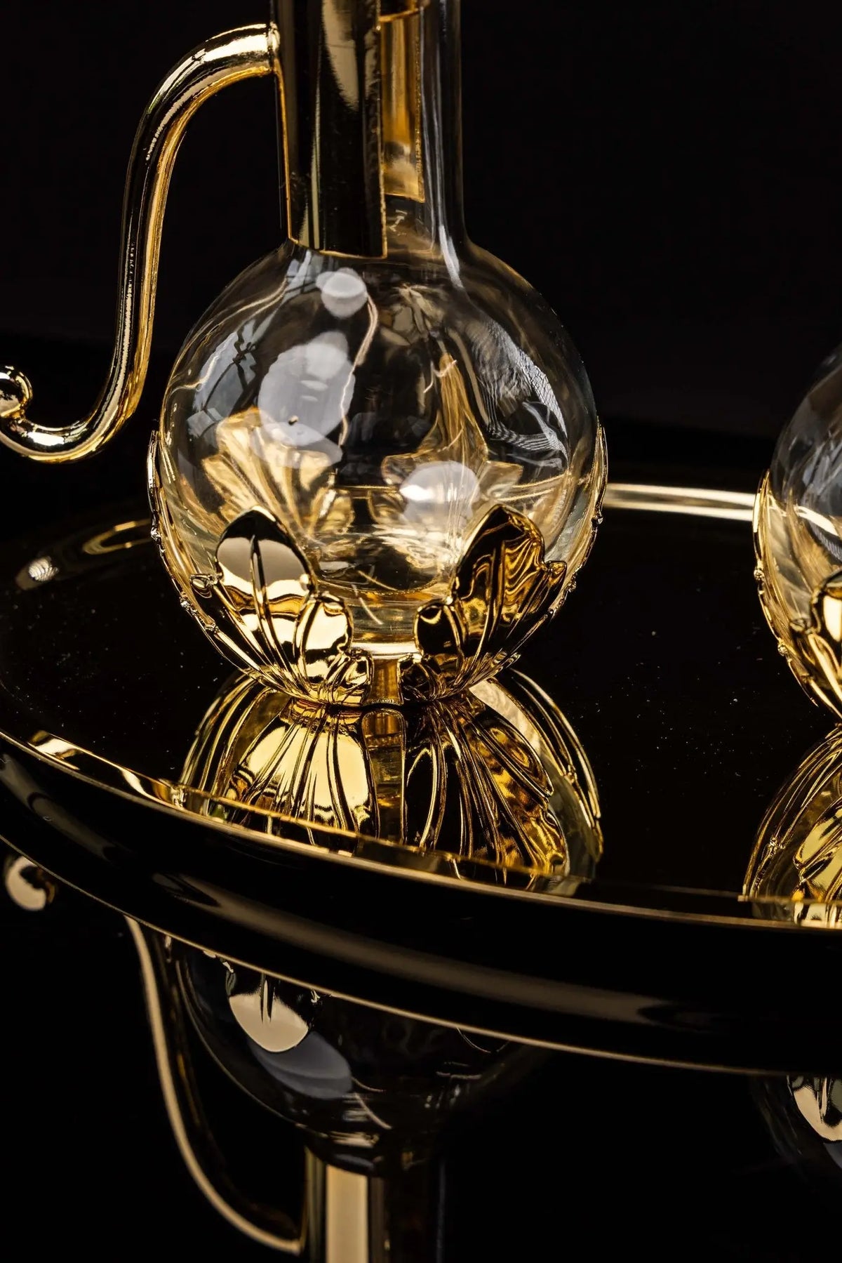 Gold liturgical cruet with floral accents, handle and cross lid, close-up view